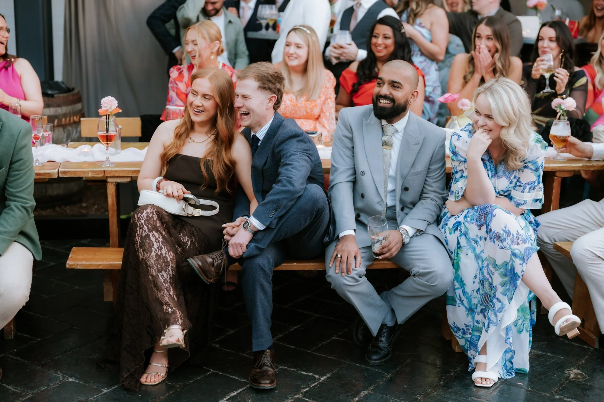 A guest laughing heartily during the wedding speeches.