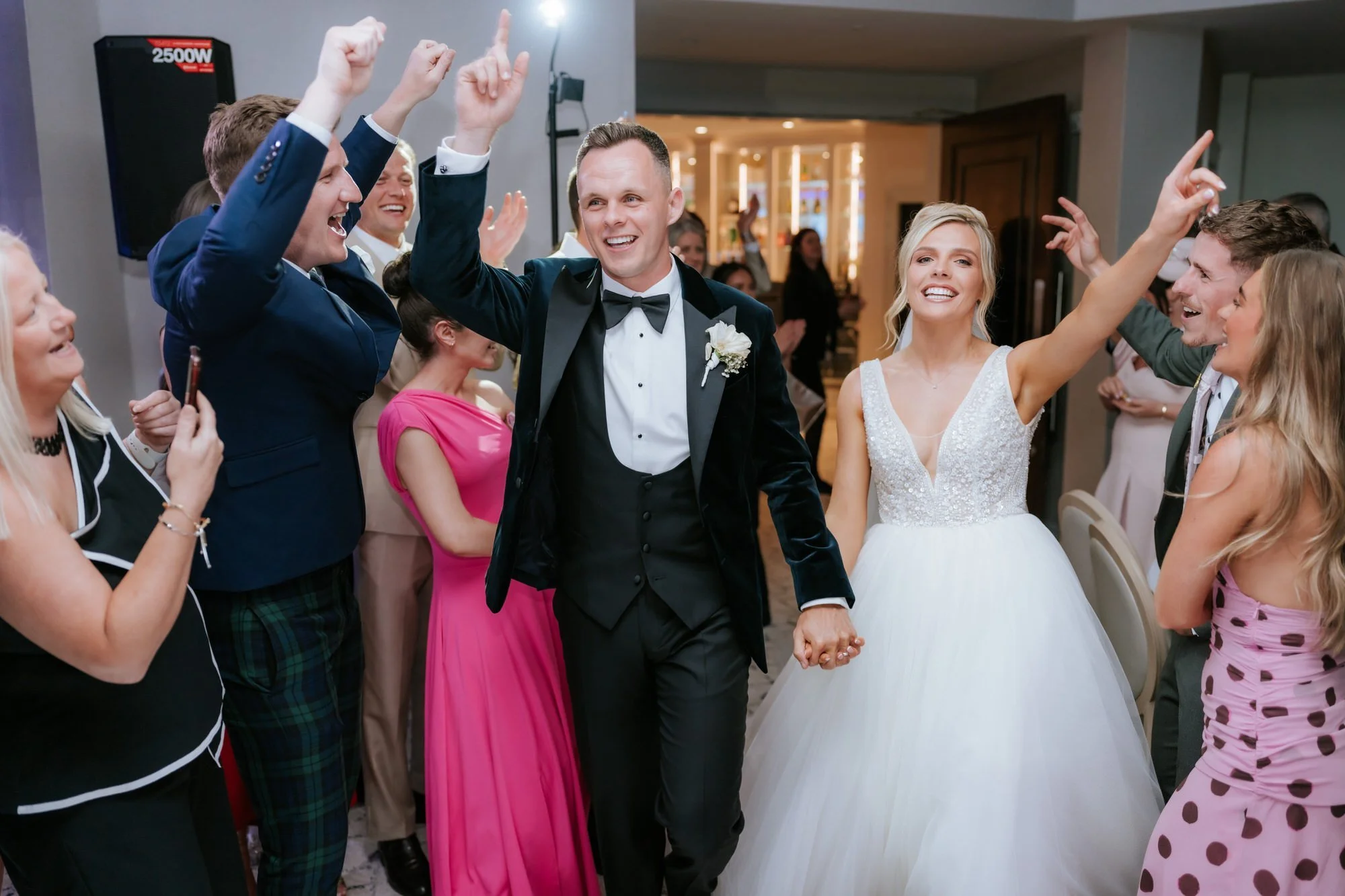 Nicole and Lawrence entering the evening party with their hands raised.