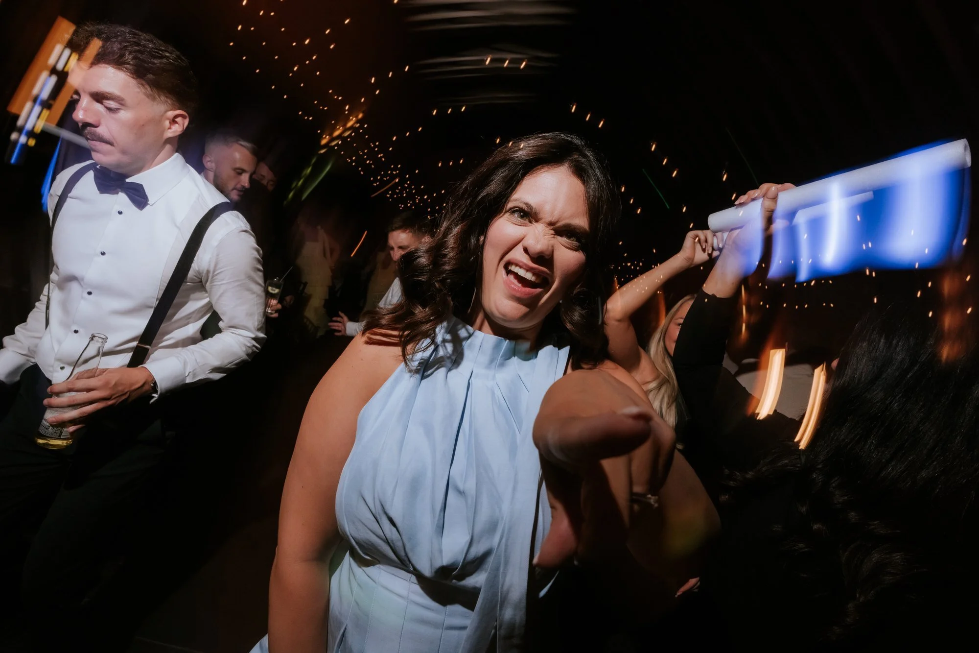 A guest in a pale blue dress dancing towards the camera.