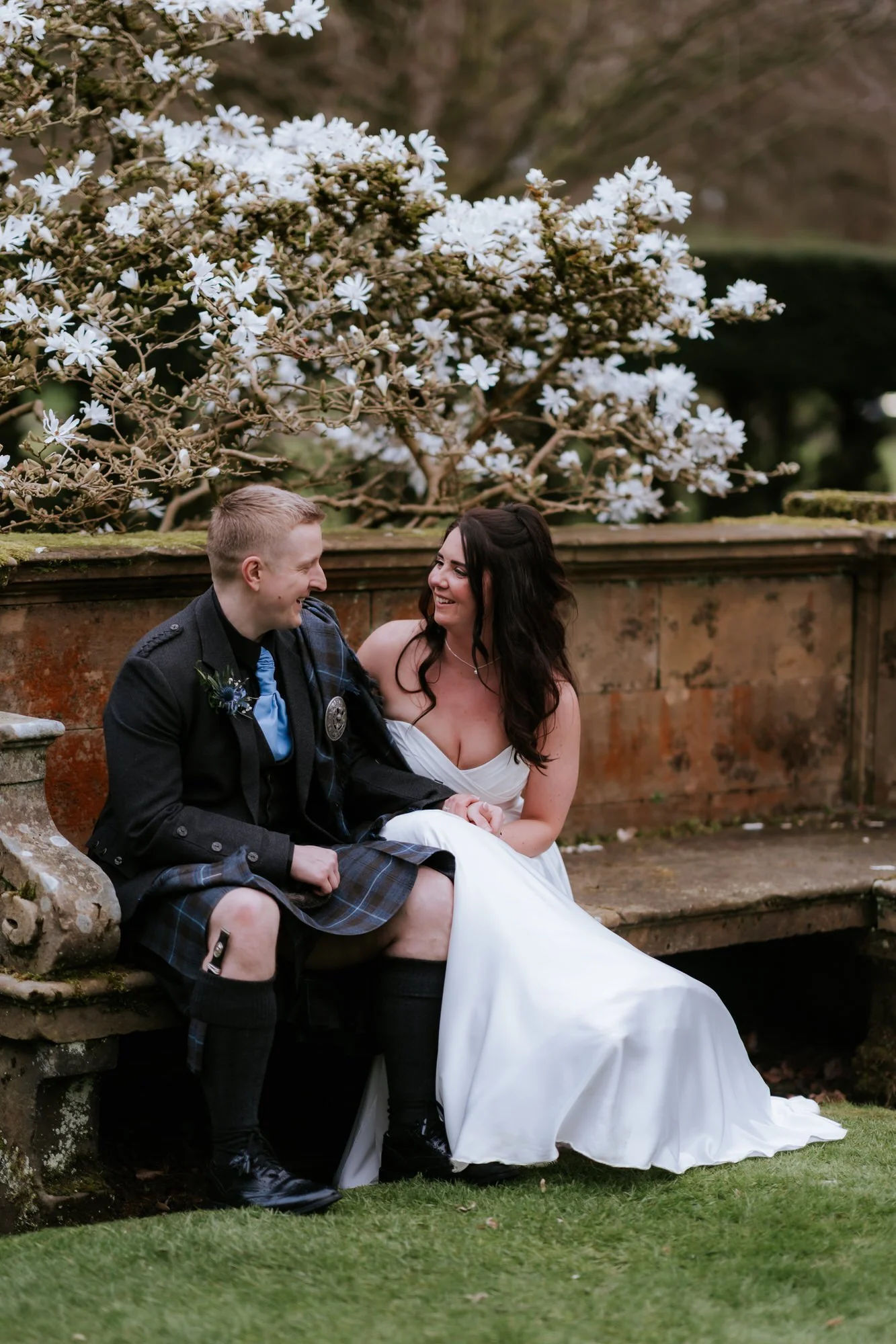 The couple sitting together on a garden bench.