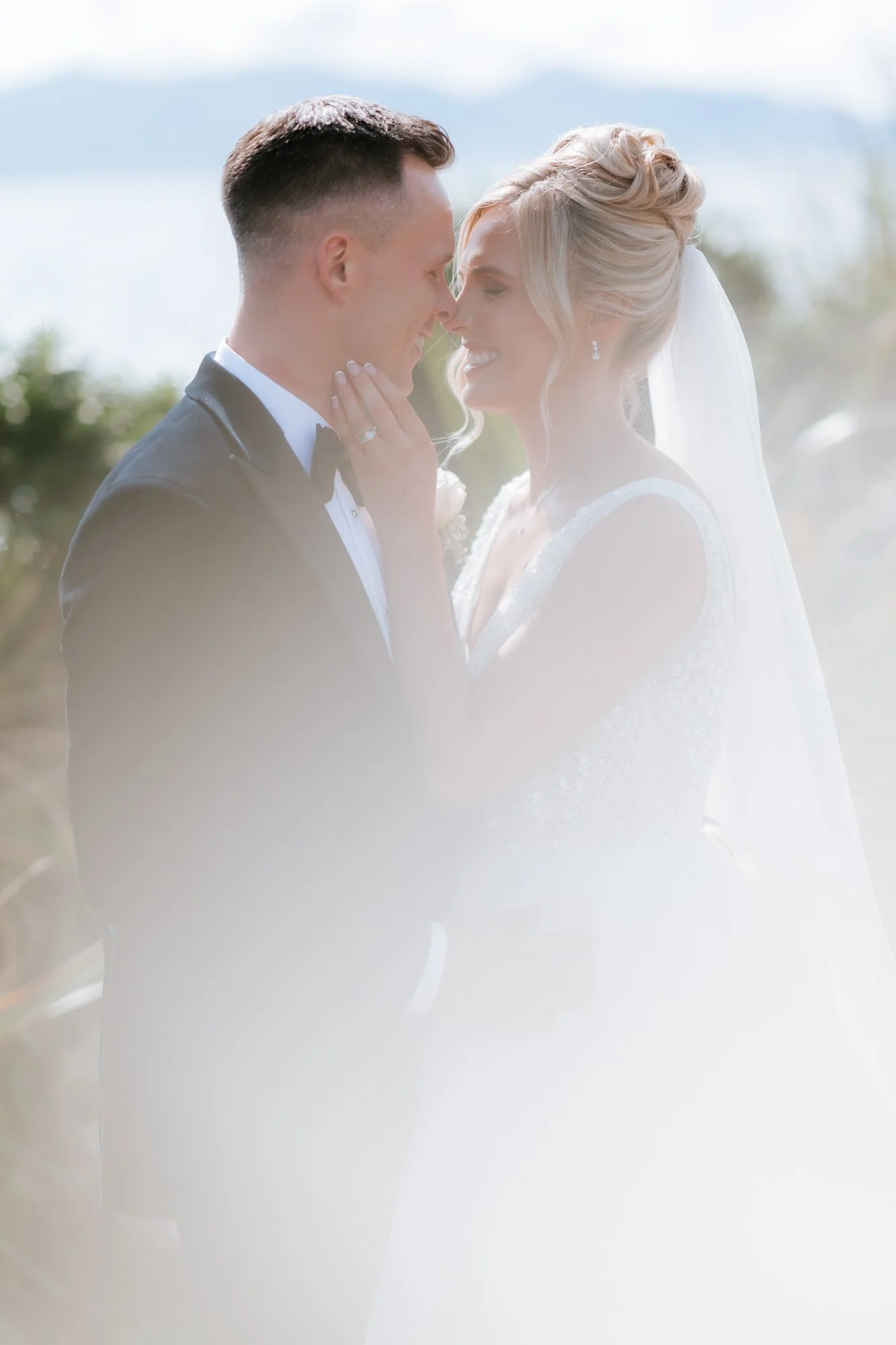 A close portrait of Nicole and Lawrence beneath her veil.
