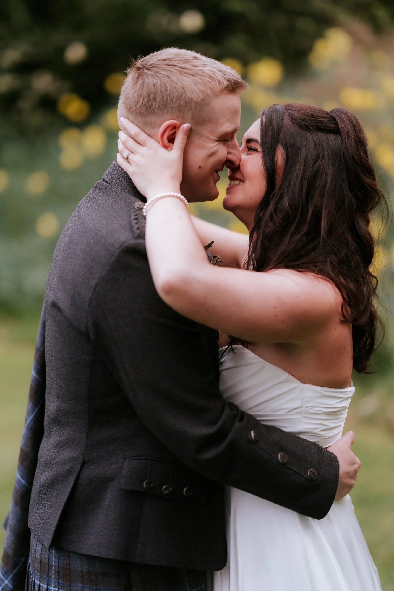 Steph and Calum smiling nose to nose in the garden.