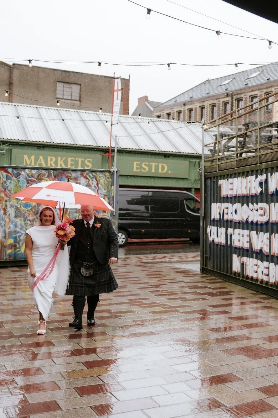 Rhona arriving at BAaD beneath an umbrella.