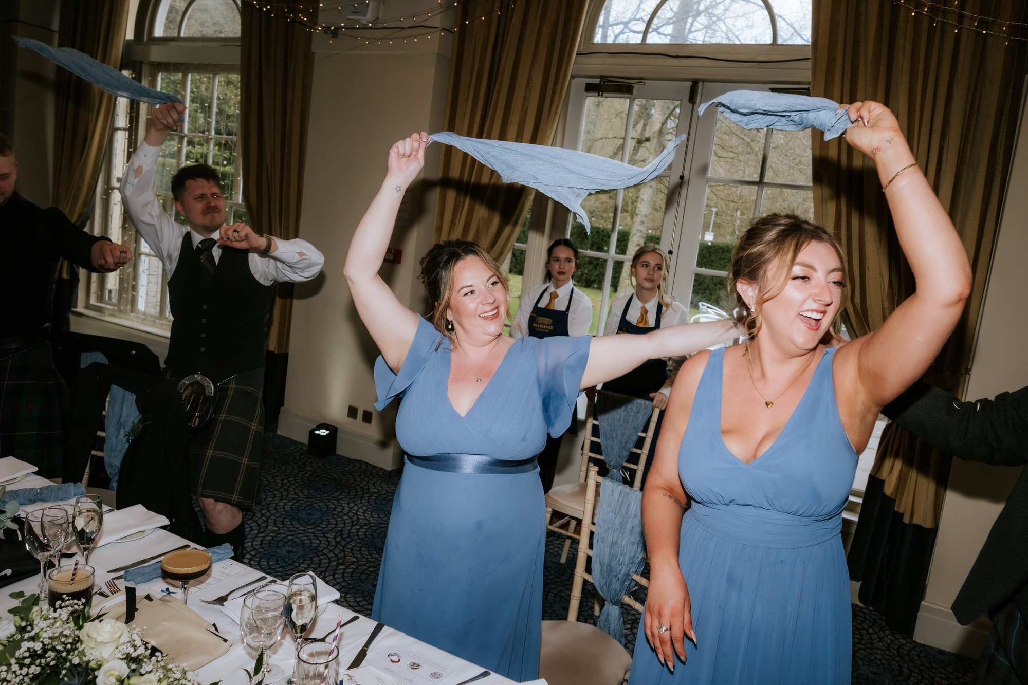 The bridesmaids celebrating with napkins raised at the wedding breakfast.