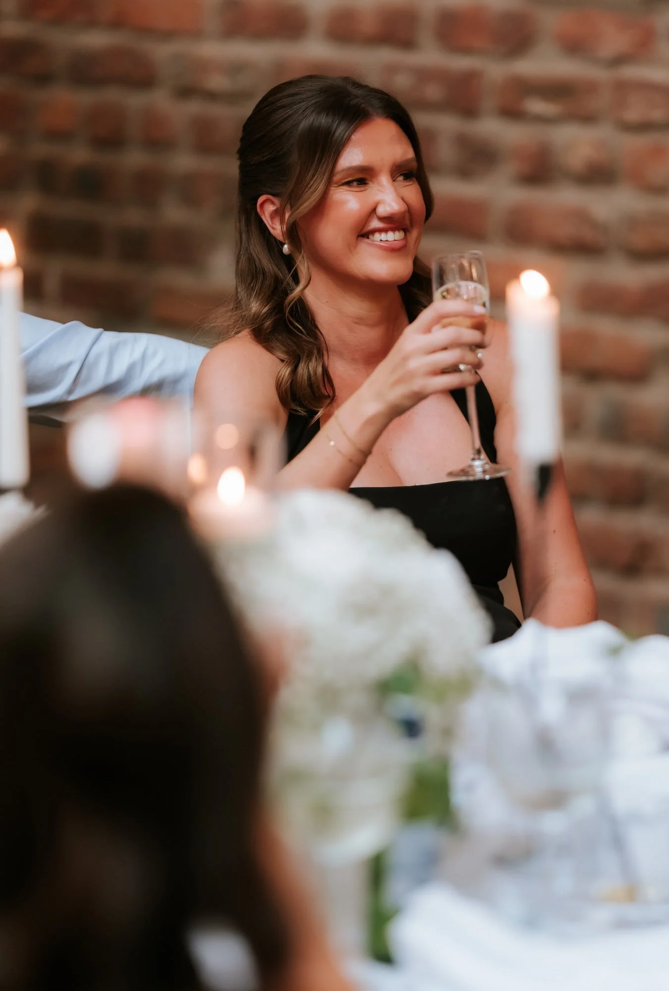 A wedding guest holding a champagne glass during the reception.