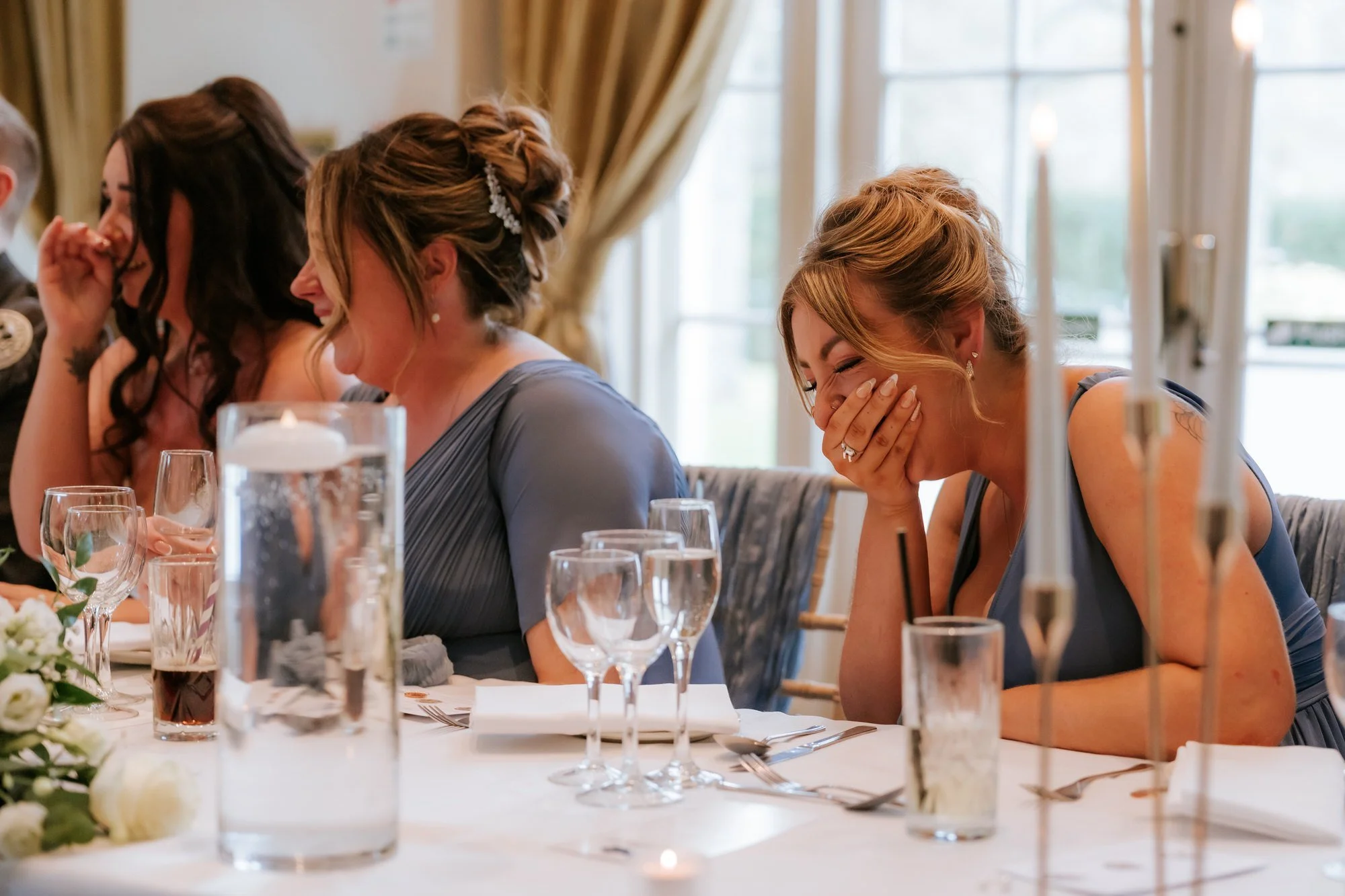 The bridesmaids laughing together at the top table.