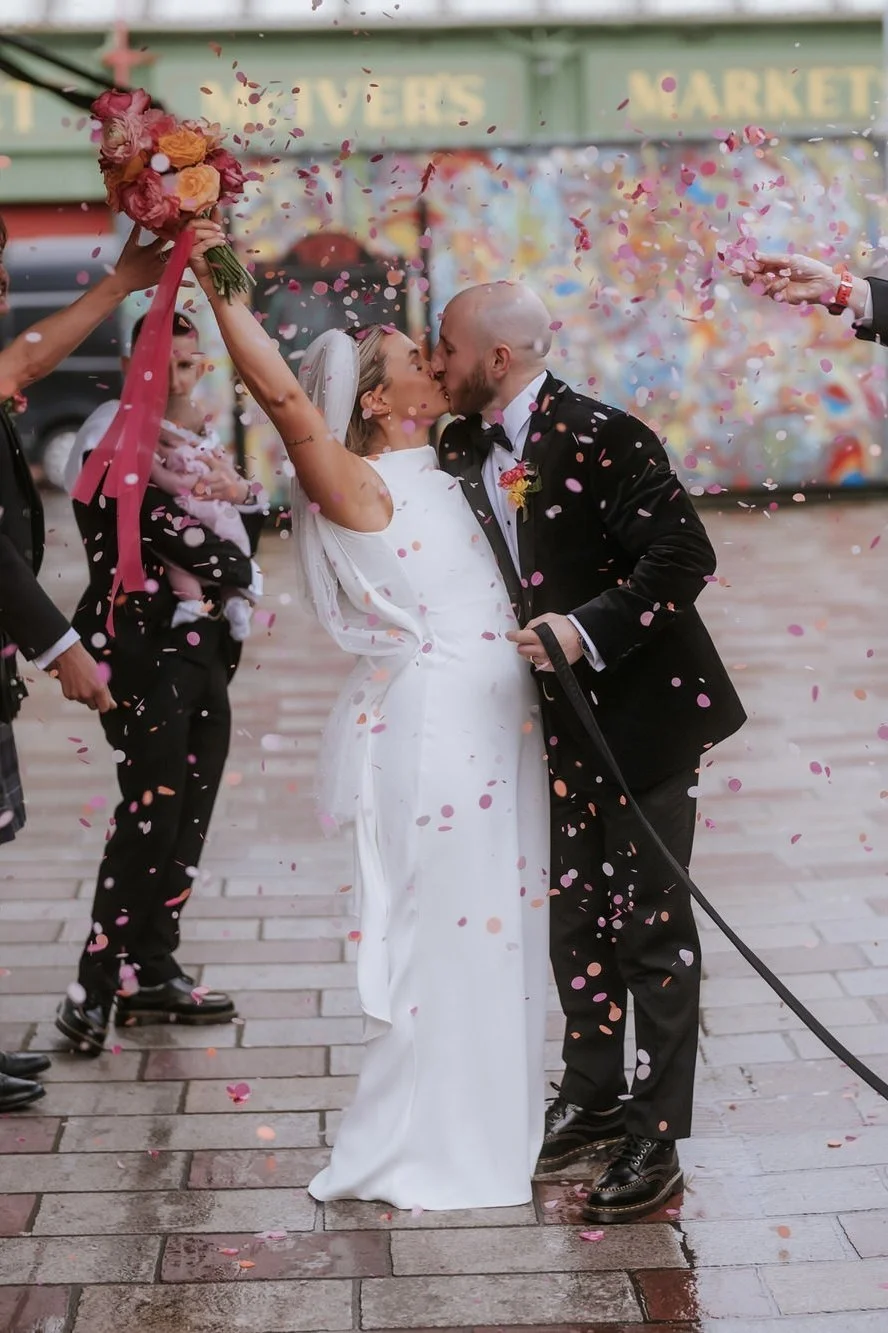Rhona and Ciaran kissing as confetti falls around them.