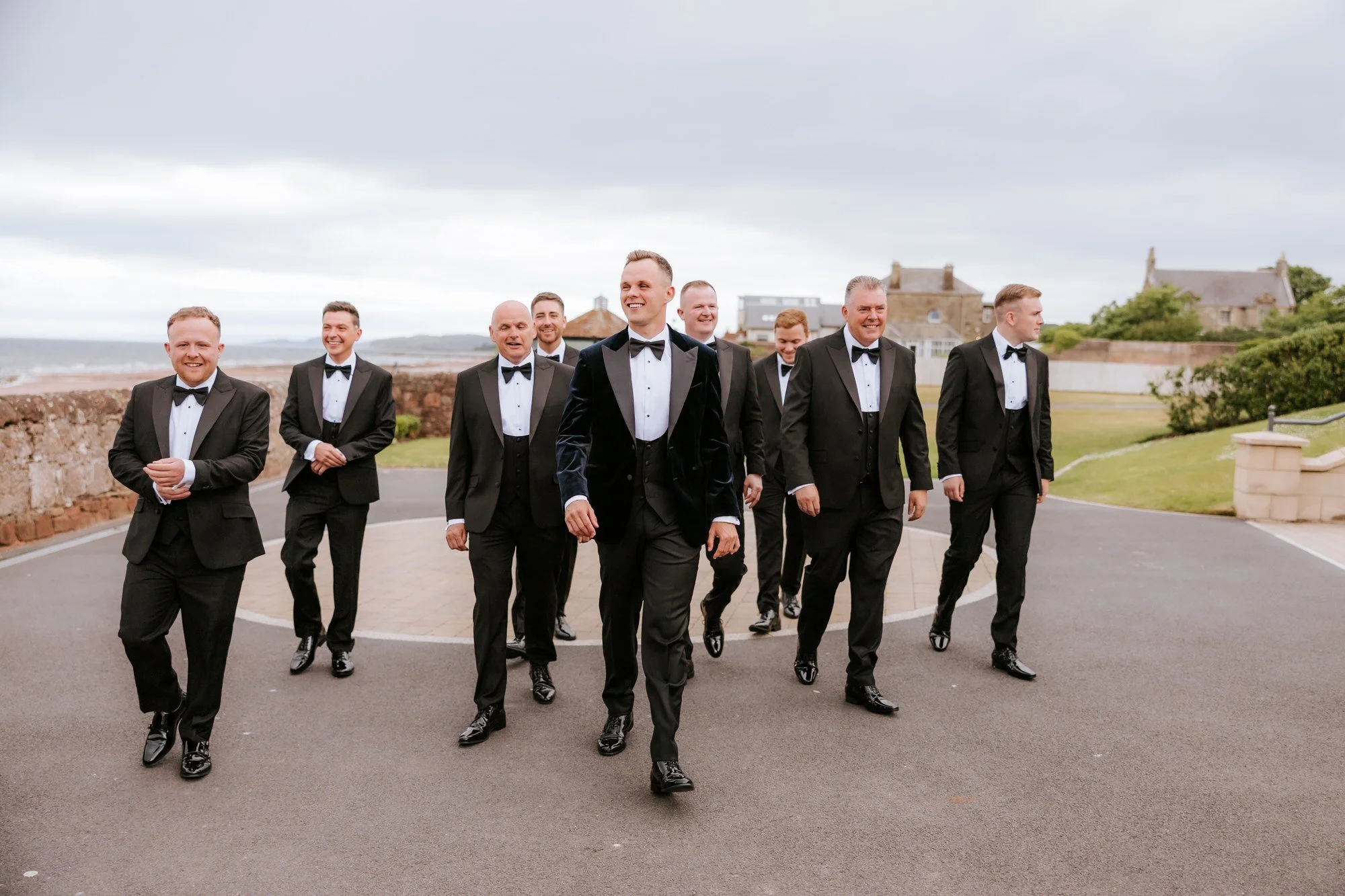 The groom and groomsmen walking together outside the hotel.