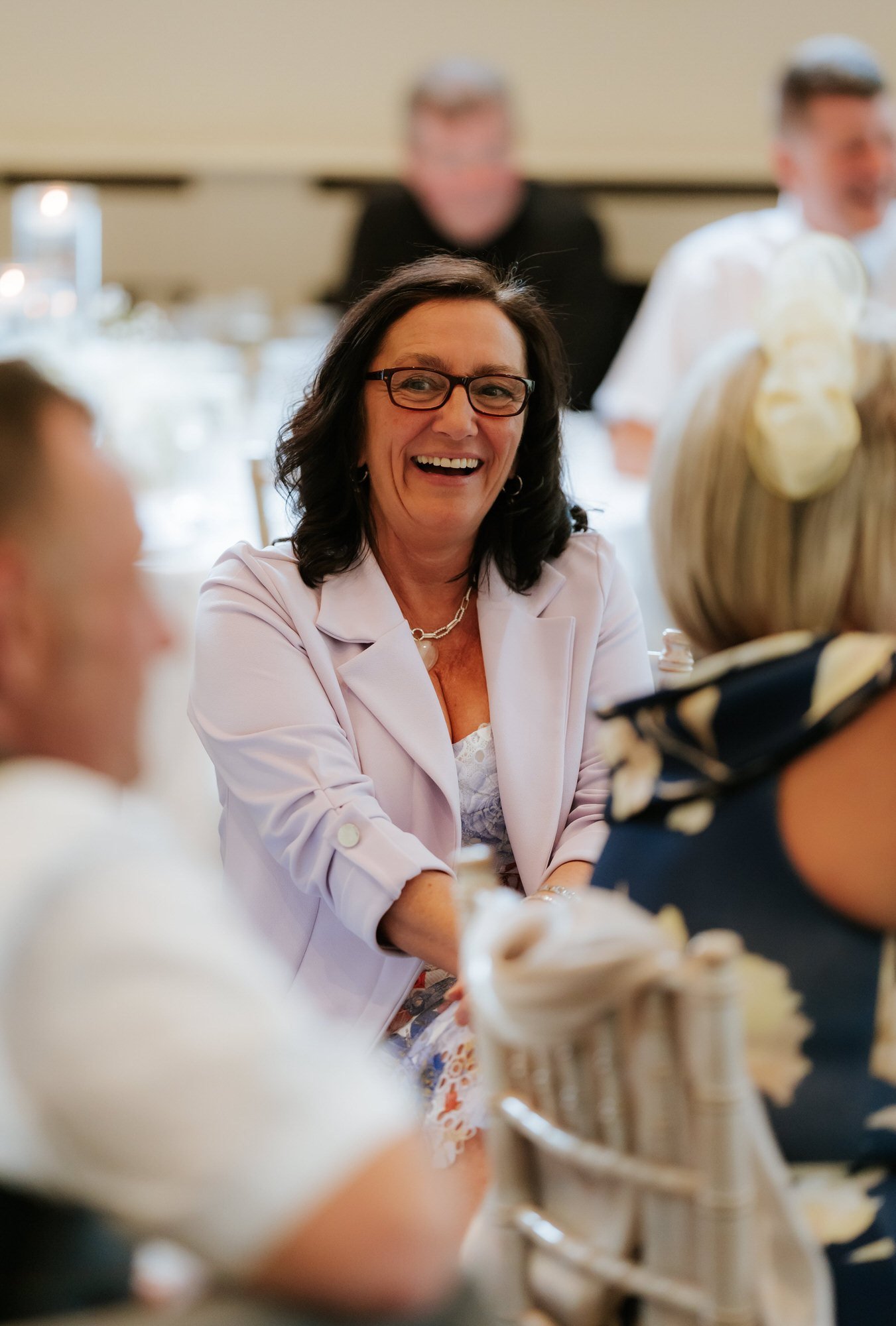 A guest in lavender laughing during the reception.