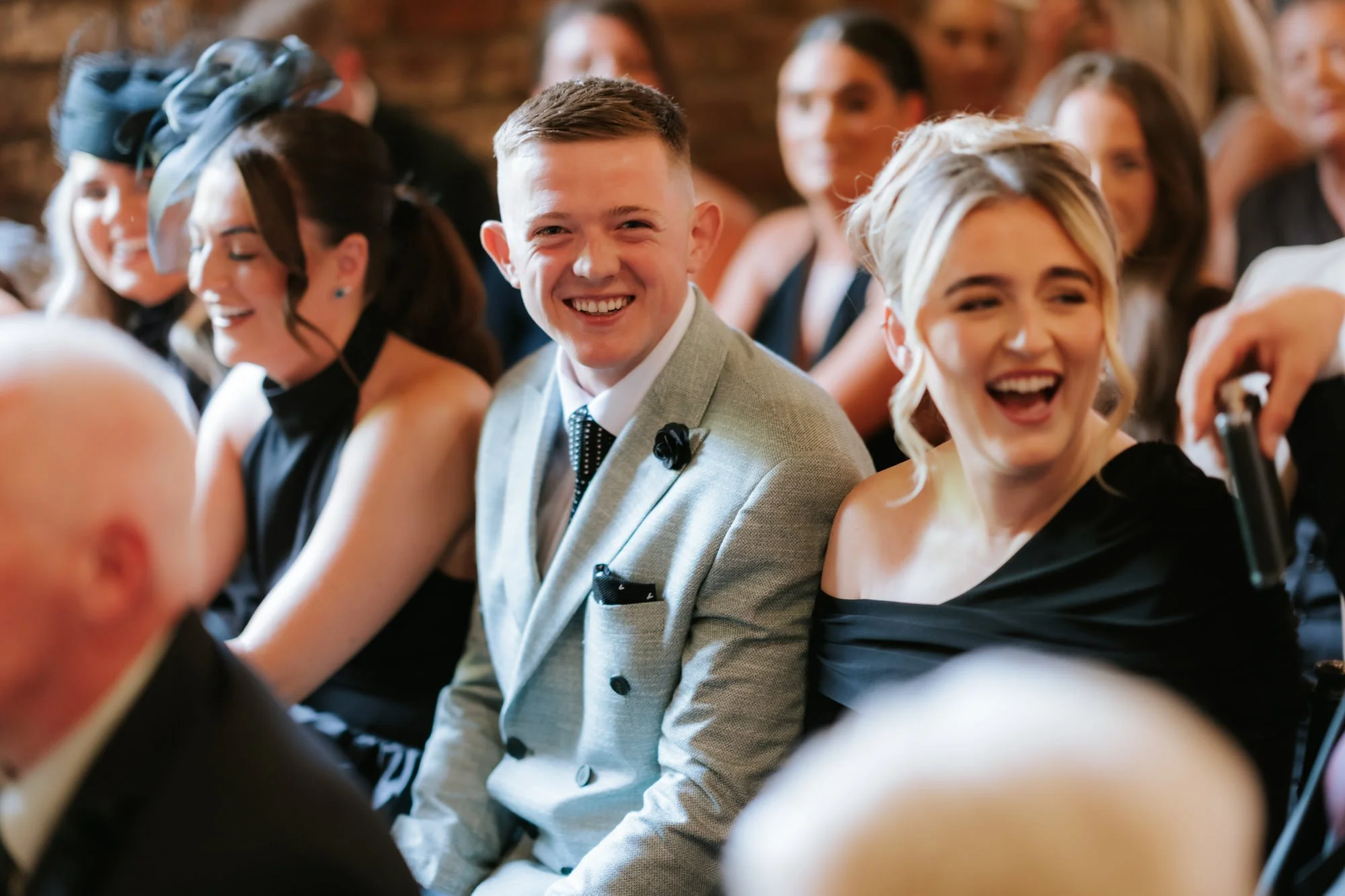 Wedding guests laughing during Caitlin and Craig's ceremony.