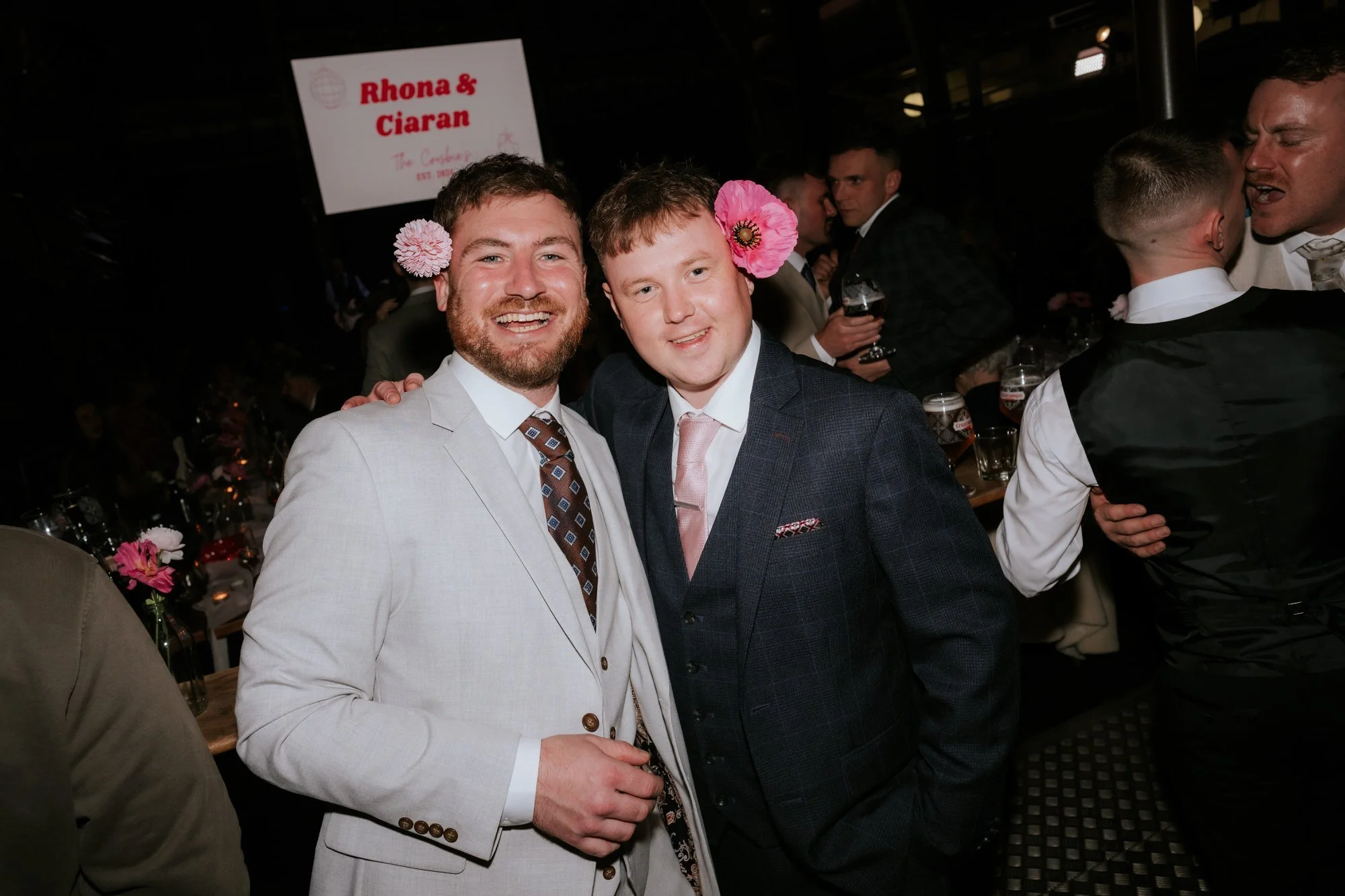 Guests laughing with flowers tucked behind their ears.