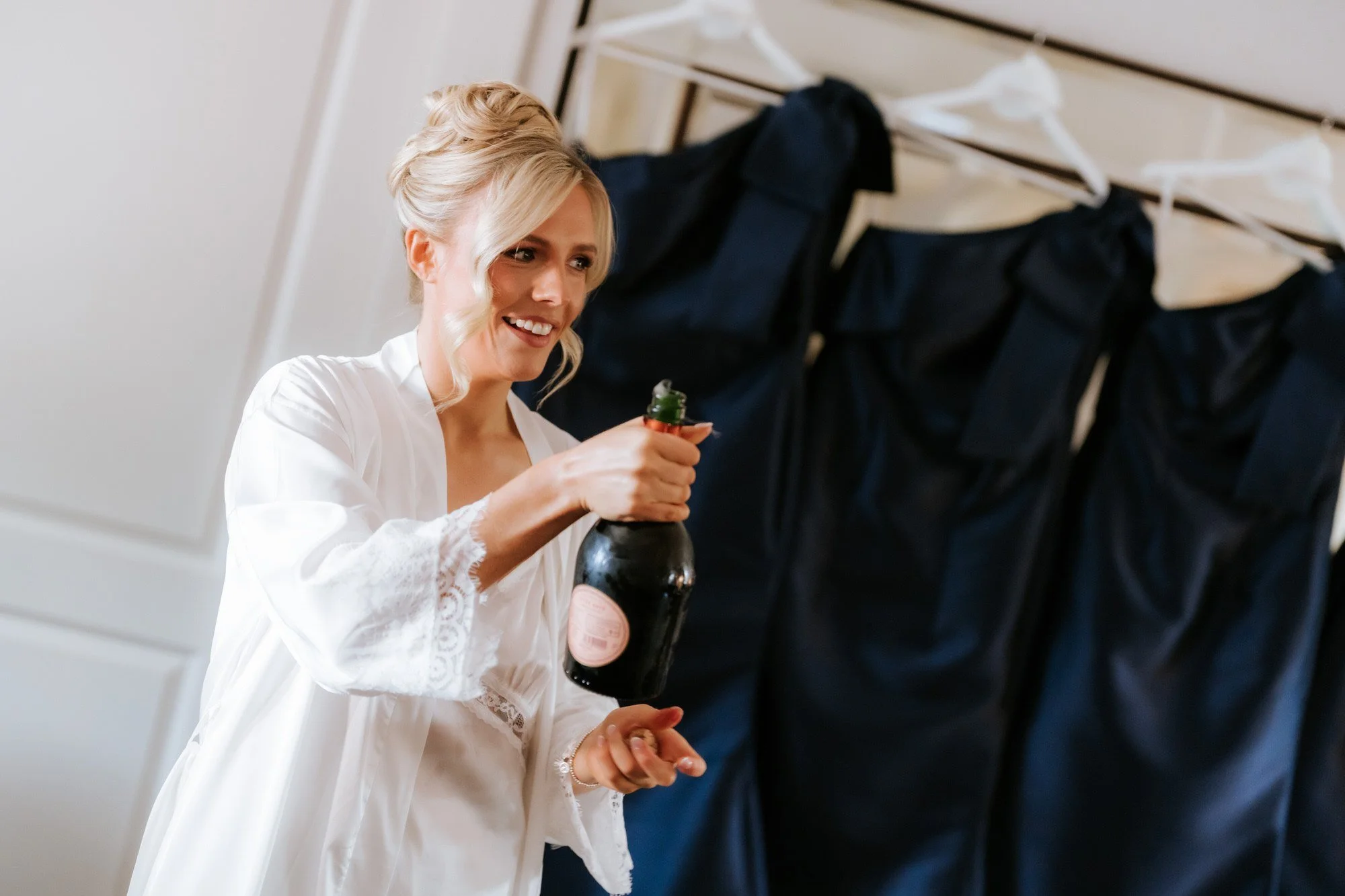 Nicole opening champagne during her wedding preparations.