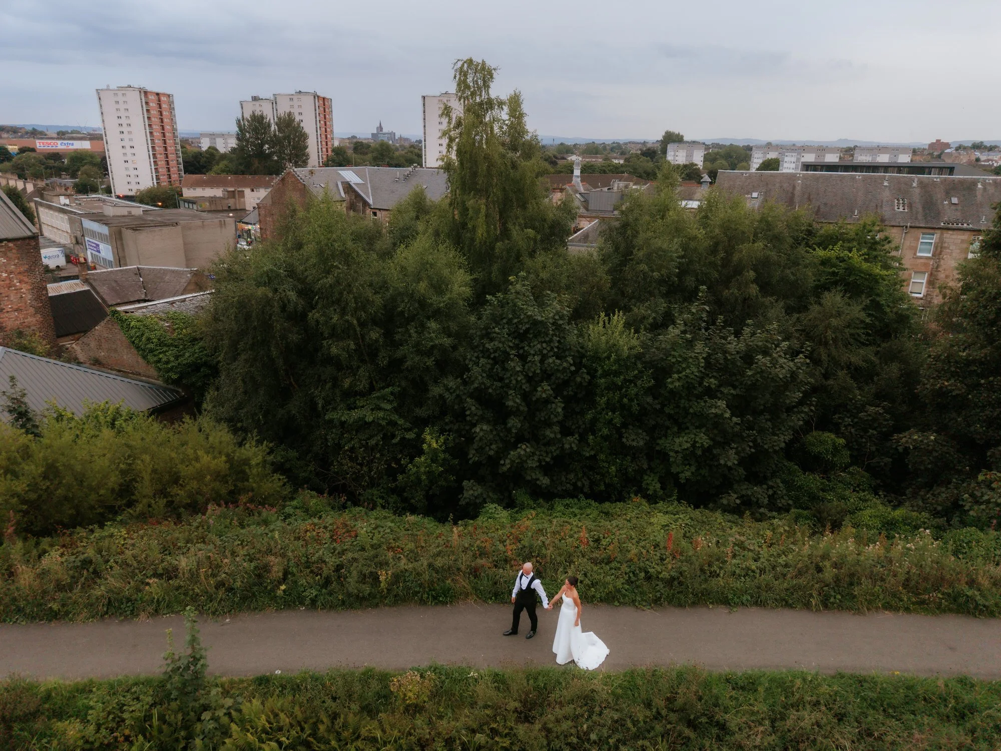 An aerial view of Caitlin and Craig on the canal path with Glasgow beyond.