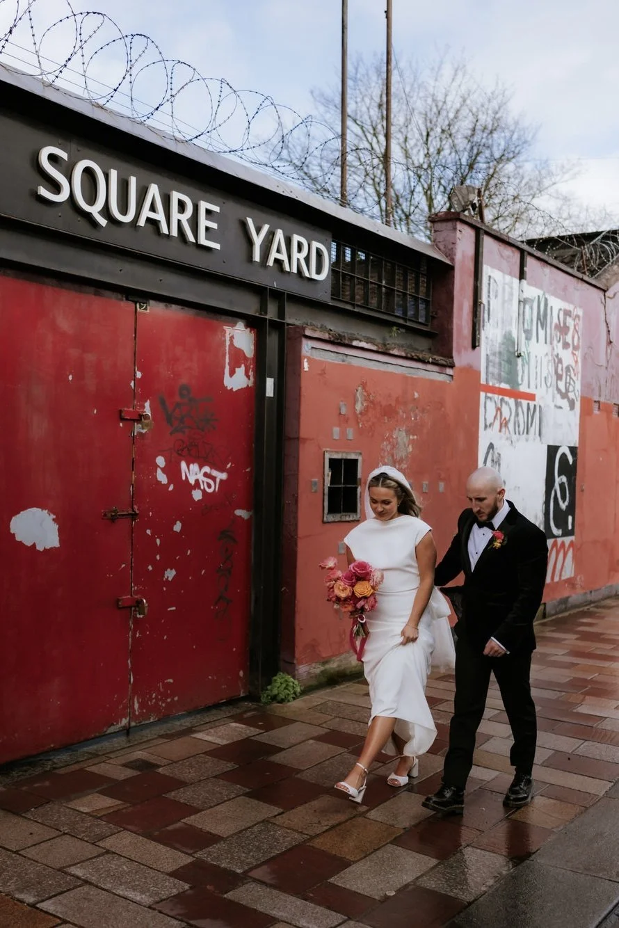 Rhona and Ciaran walking past the colourful Square Yard frontage.