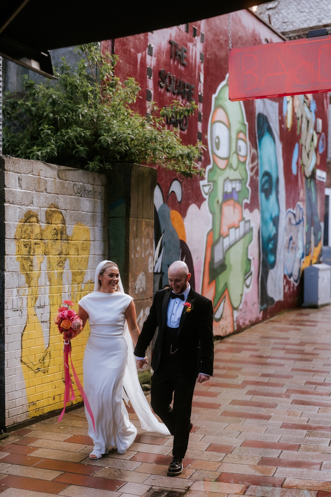 The newlyweds walking past street art near BAaD.