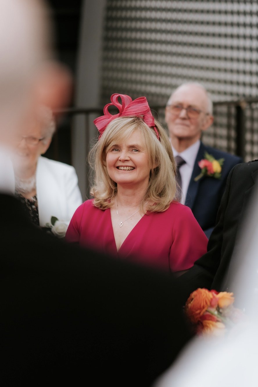 A guest smiling during the wedding ceremony.