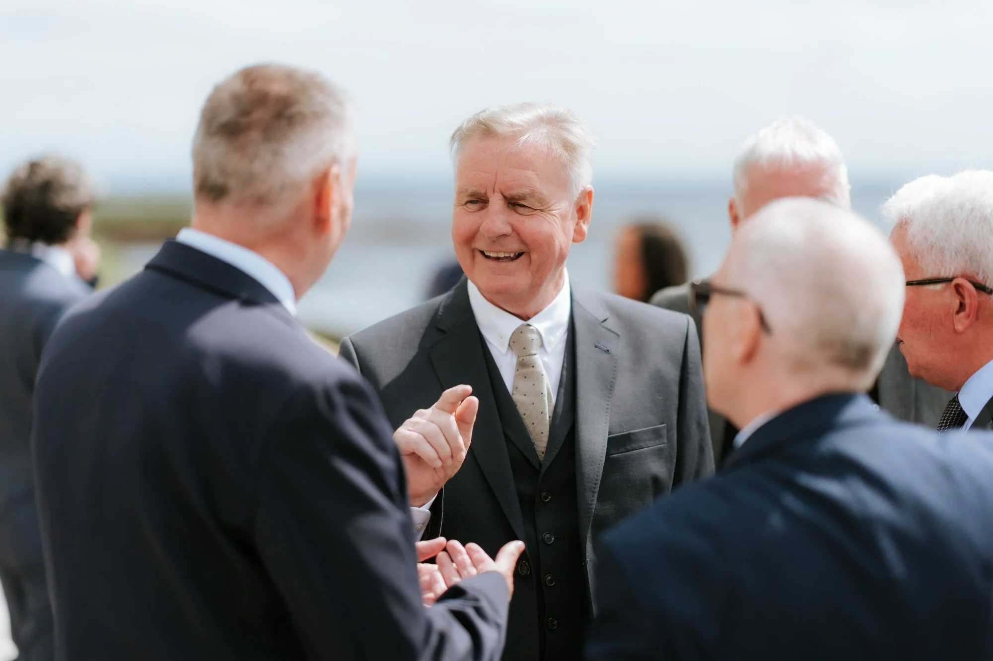 Guests chatting and smiling outside during the drinks reception.