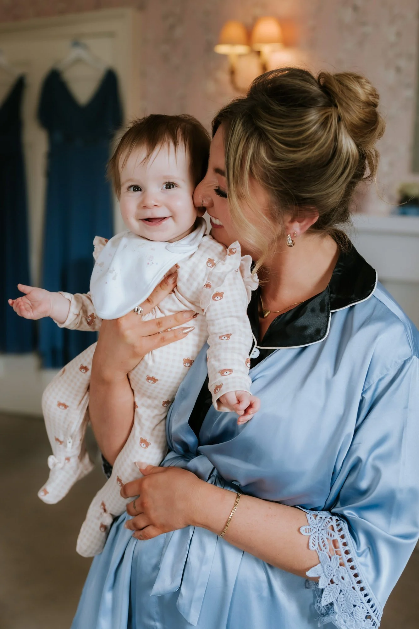 A bridesmaid holding the baby during wedding morning preparations.