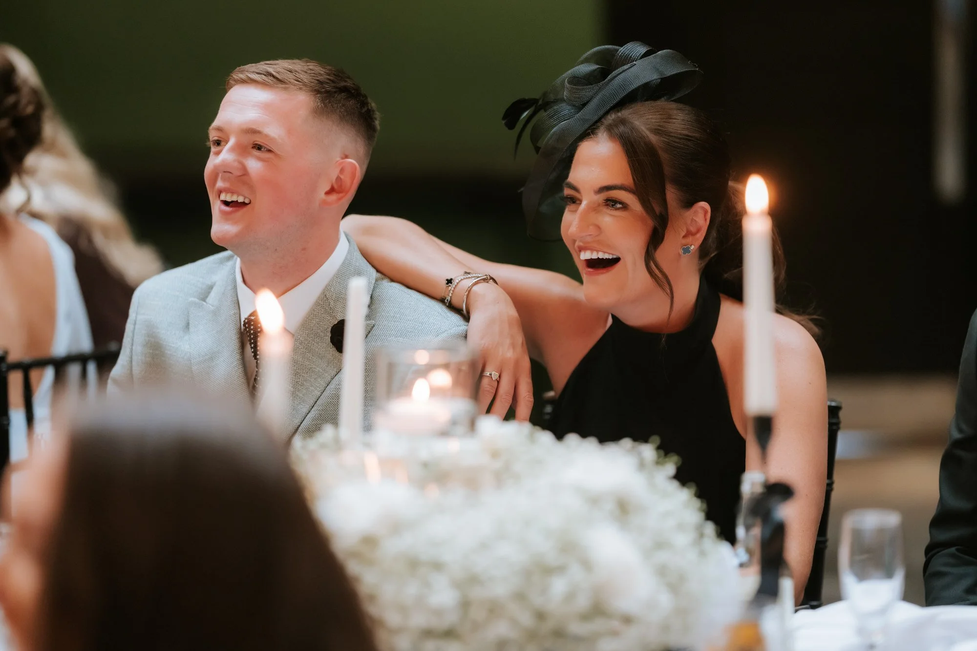 Two guests smiling together during the speeches.