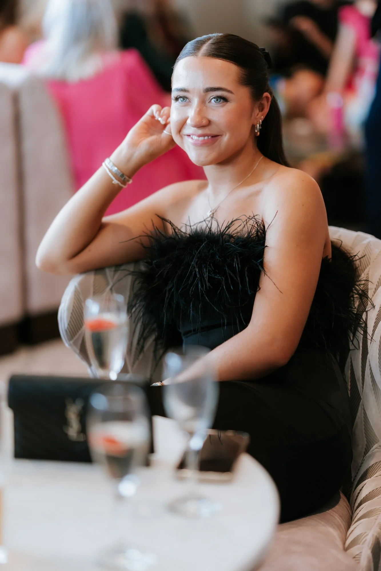 A guest in a black feathered dress enjoying the reception.