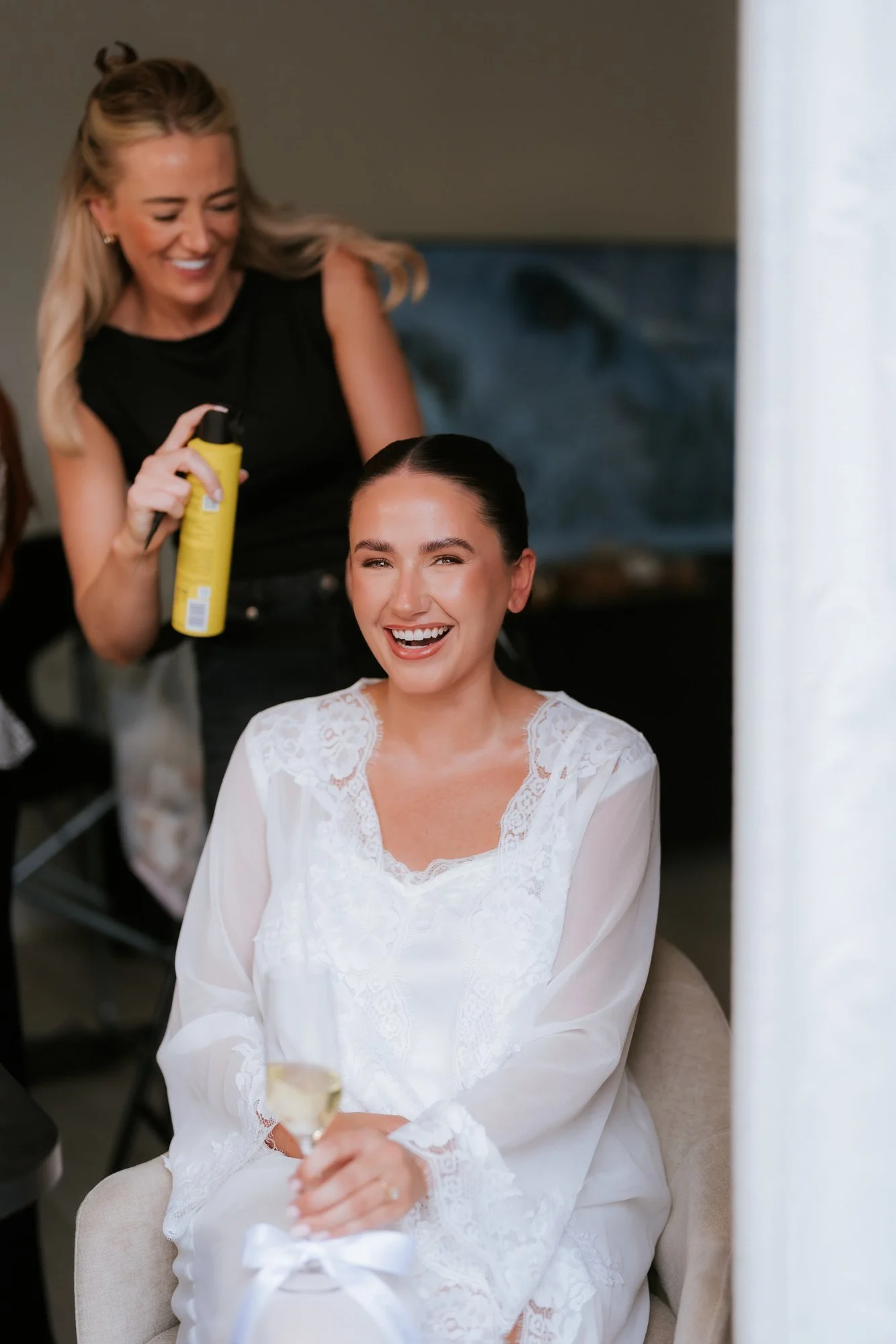 Caitlin laughing while having her hair styled on her wedding morning.