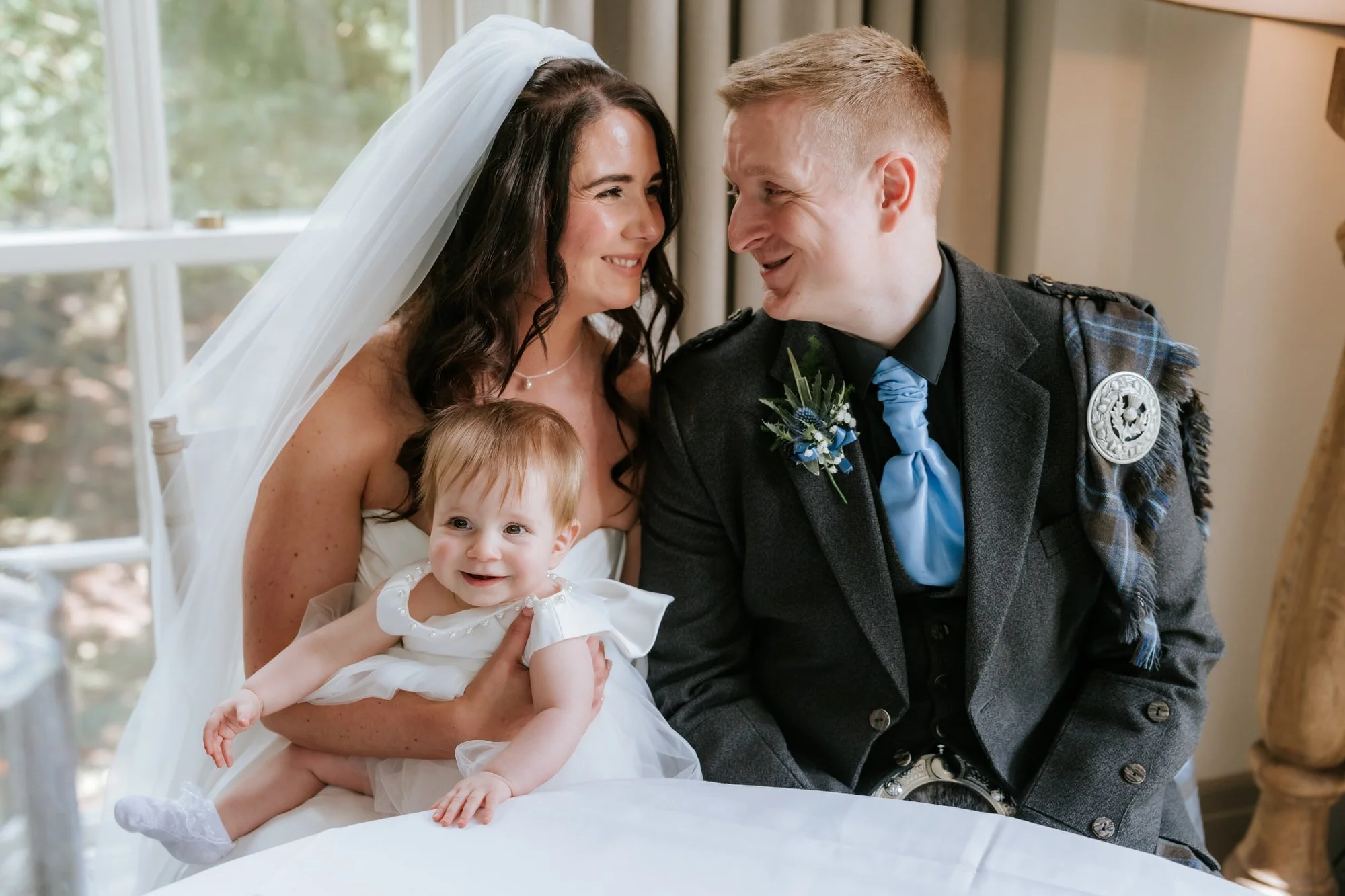 Steph and Calum with their baby while signing the wedding documents.