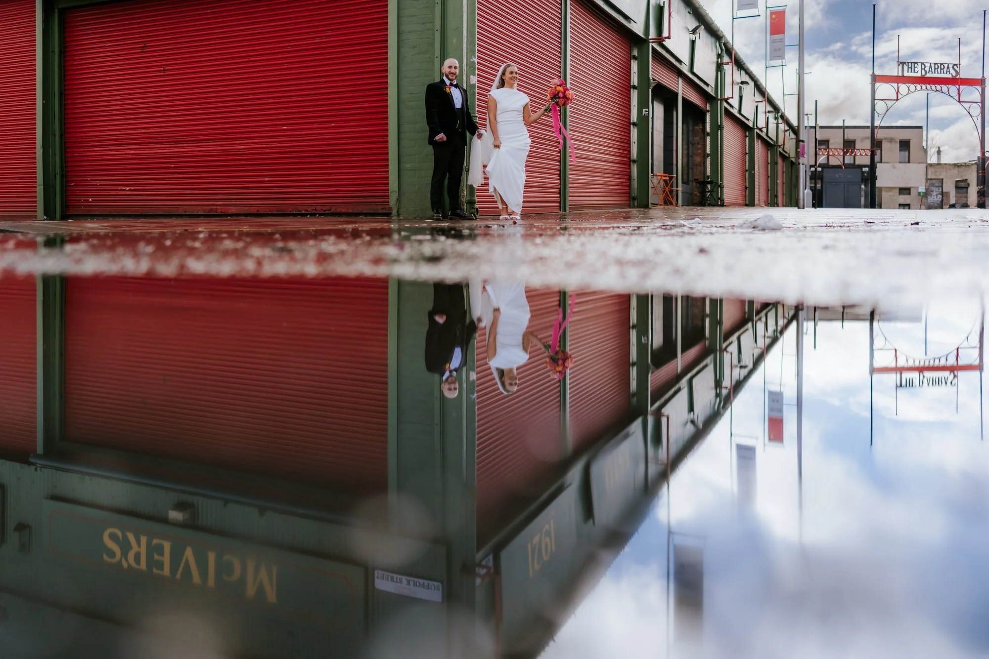 The couple reflected in a puddle outside McIver's in the Barras.
