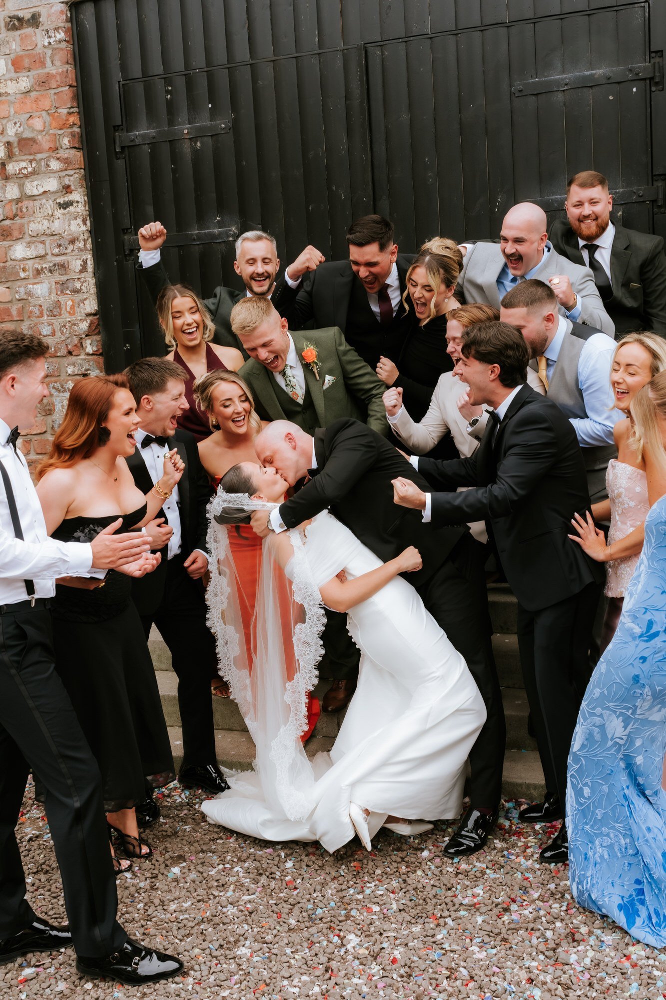 Craig dipping Caitlin for a kiss as their guests cheer around them.