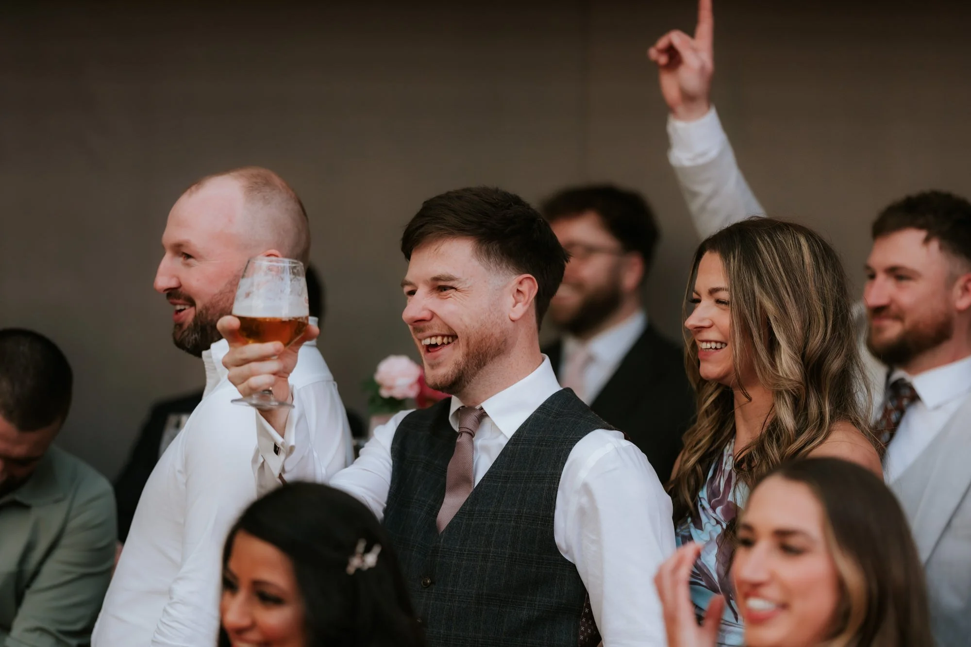 A guest raising a glass to toast the newlyweds.