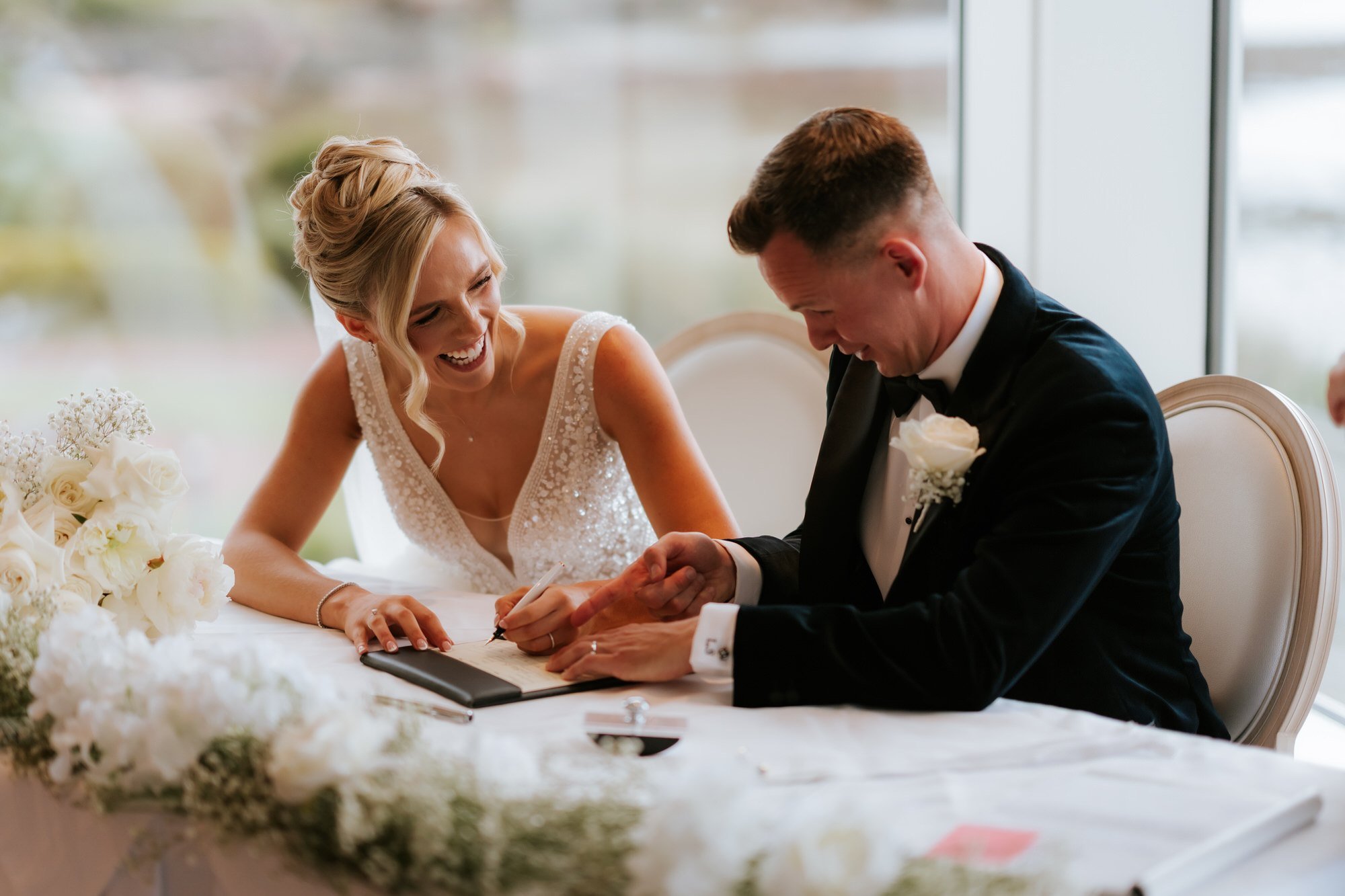 Nicole and Lawrence laughing while signing the wedding documents.