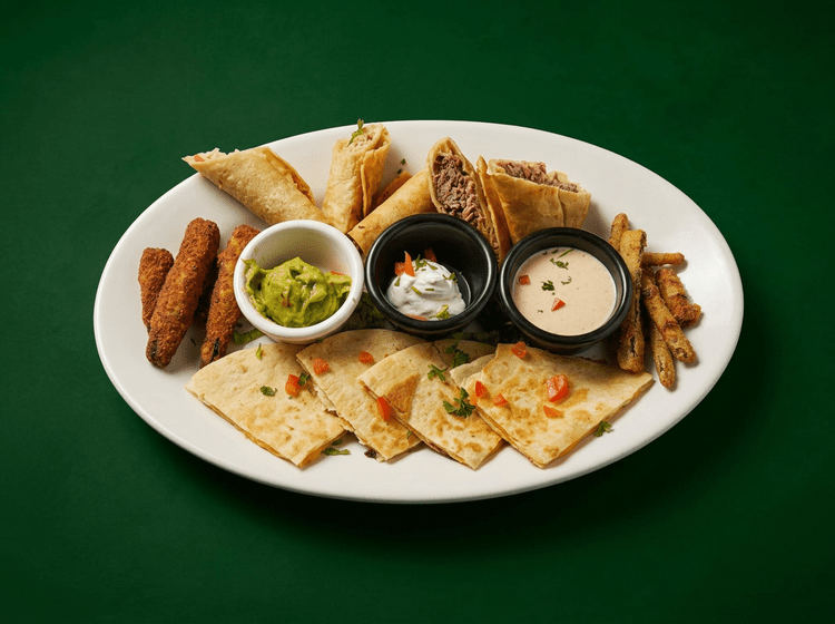 Sampler platter with taquitos, quesadilla, guacamole, sour cream and cheese dip