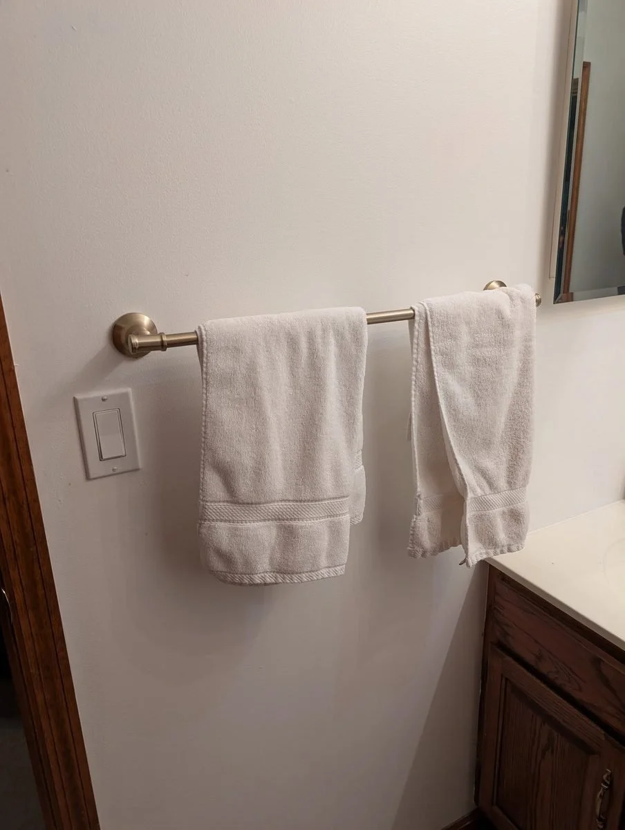 Towel bar with towels mounted in a bathroom
