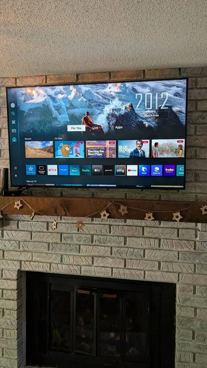 Flat-screen TV mounted above a brick fireplace