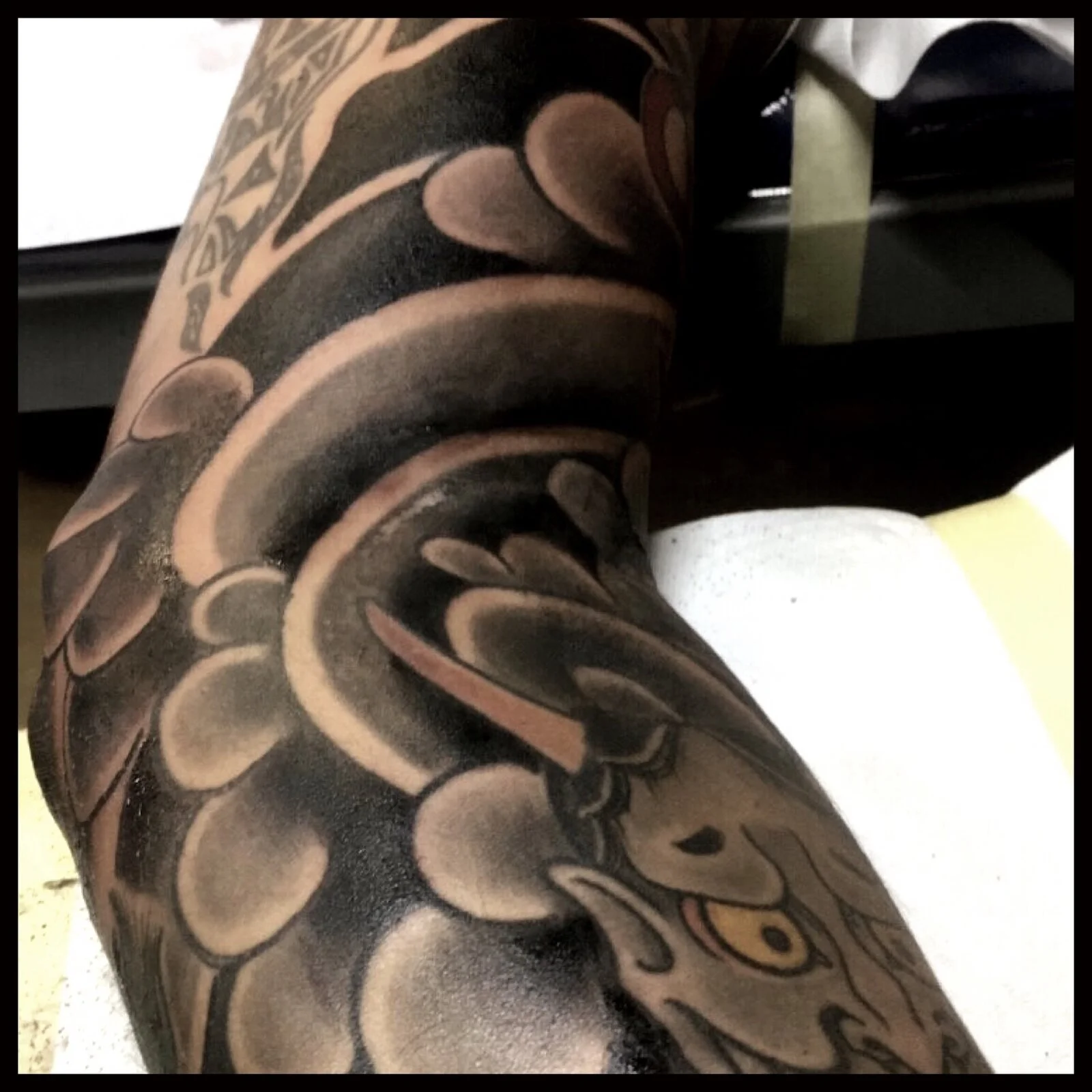 Black-and-grey Japanese snake and cloud tattoo.