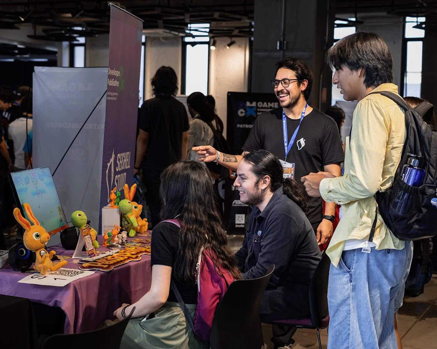 Visitantes en un booth con peluches del Indie Spot 2025