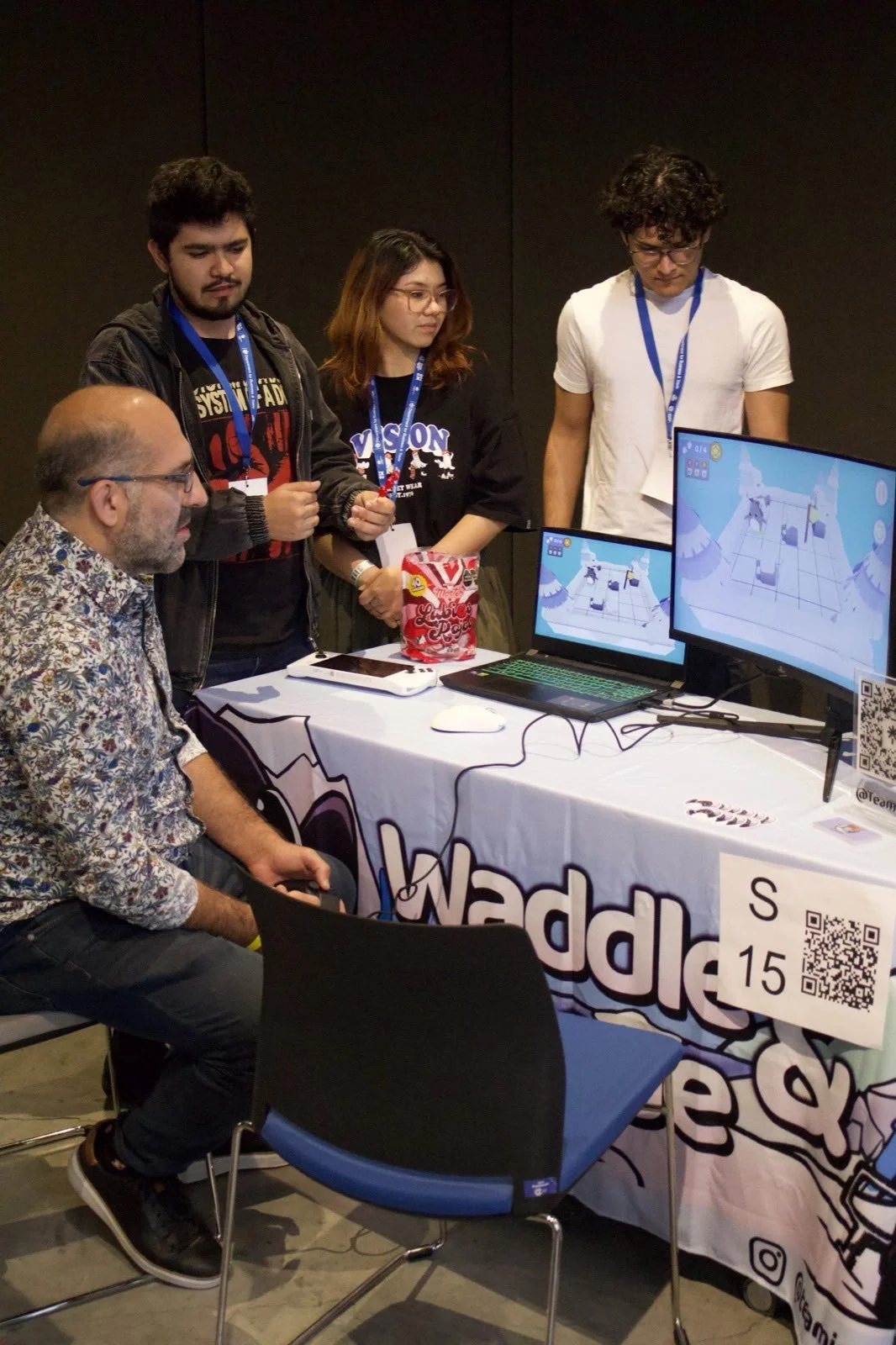 Asistentes probando un juego junto a su equipo de desarrollo en Indie Spot 2025