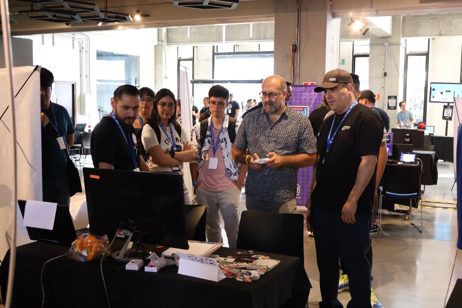 Visitantes reunidos frente a la demo de un juego en el Indie Spot 2025