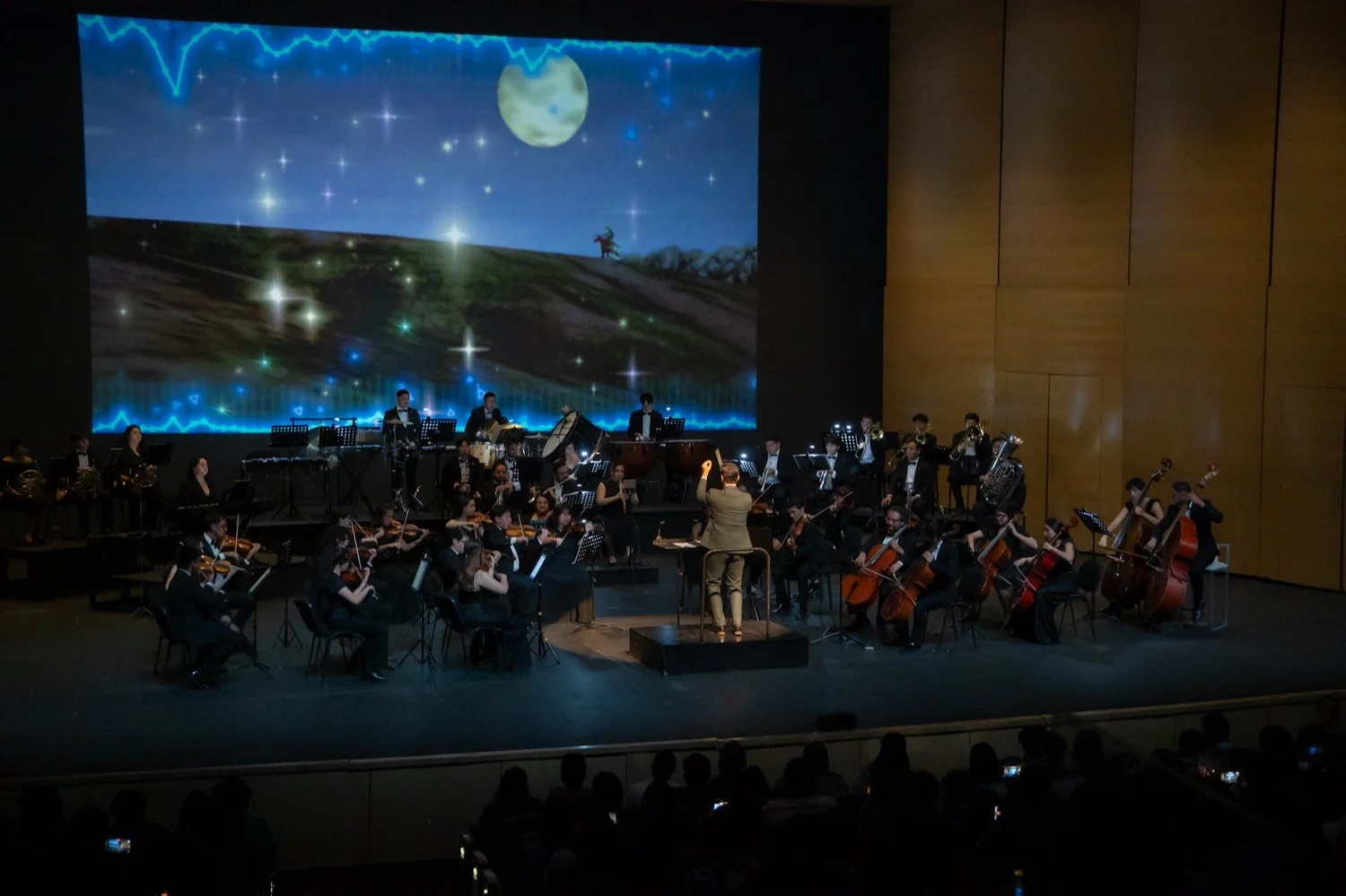 La orquesta de GameMex Sinfónico en concierto, con el arte de un videojuego proyectado en pantalla