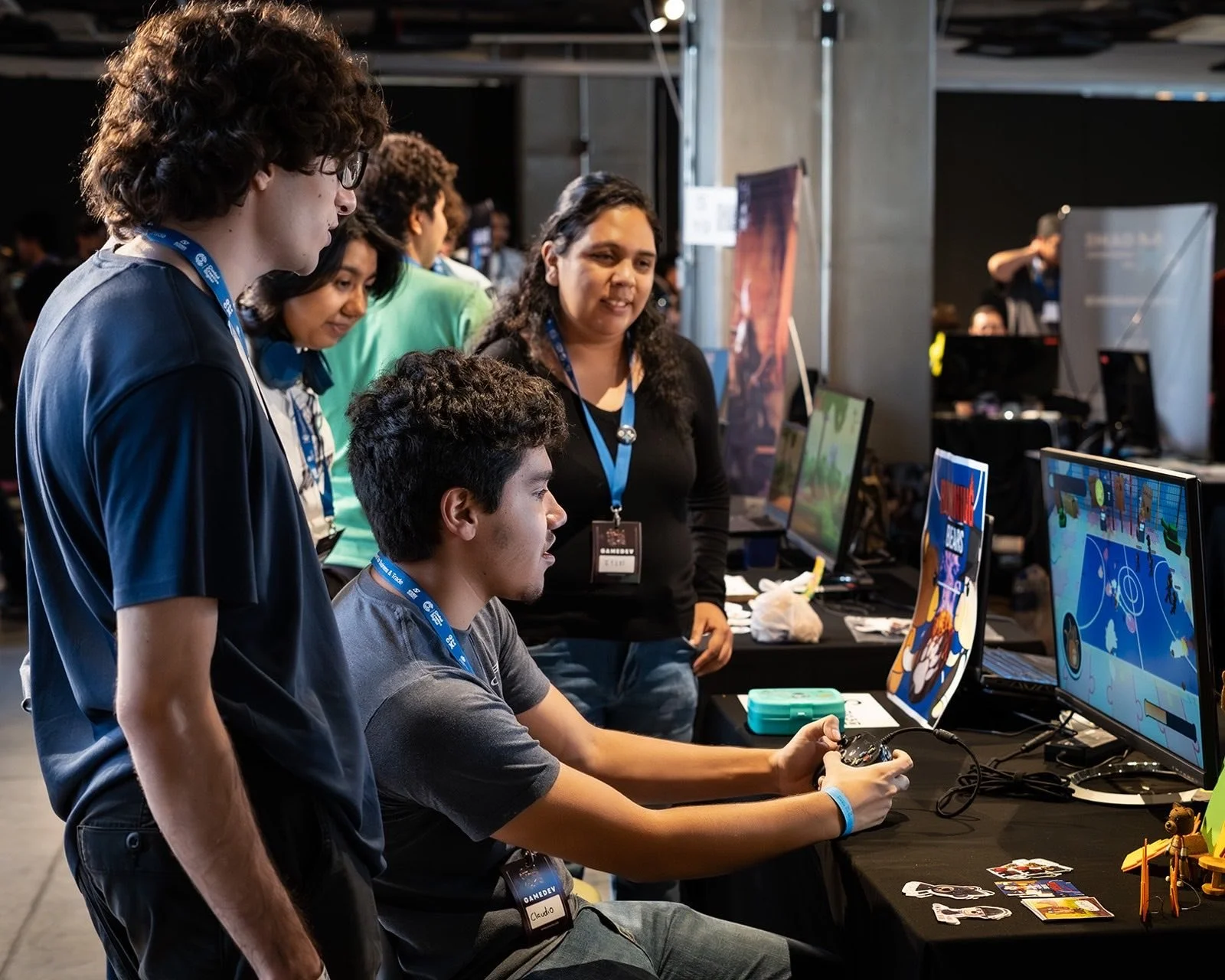 Jugadores probando juegos codo a codo en las estaciones del Indie Spot 2025