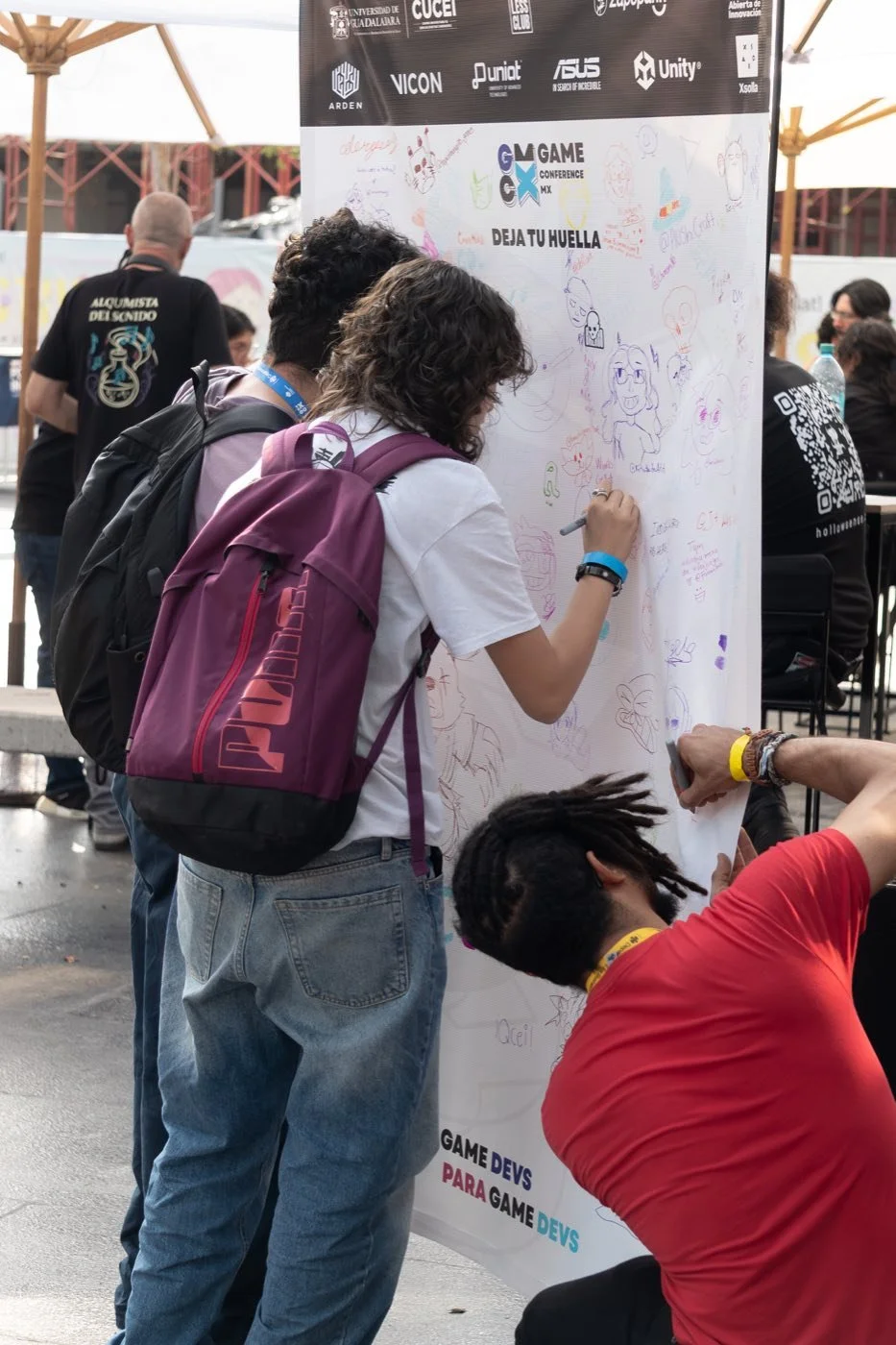 Asistentes dibujando en el muro de GCMX 2025