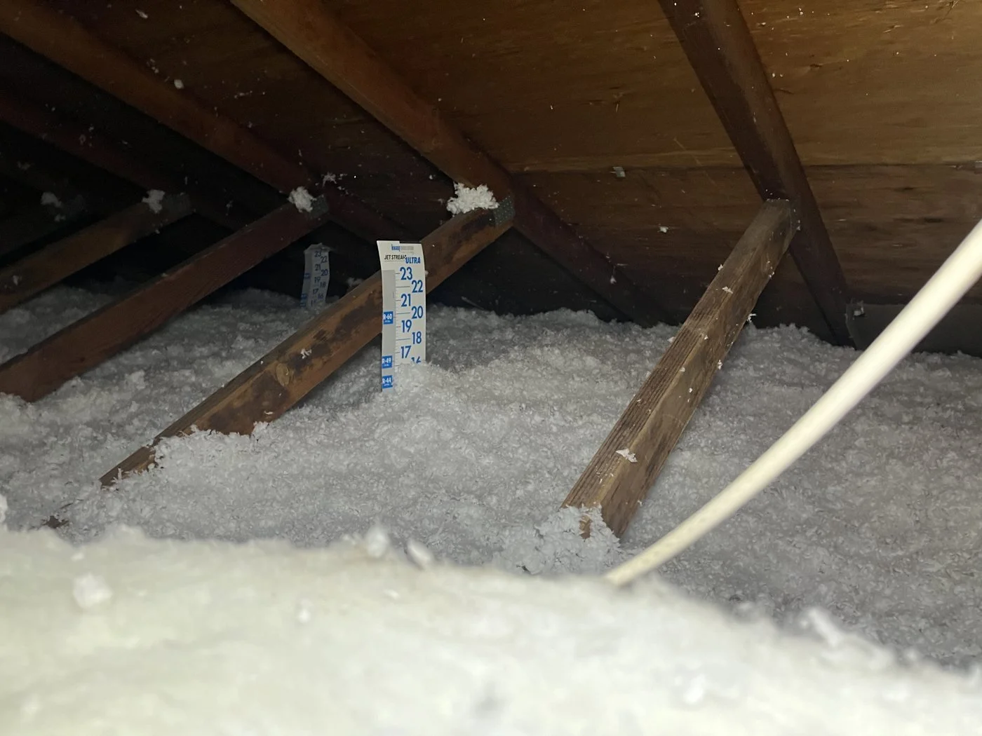 Blown attic insulation at the depth ruler
