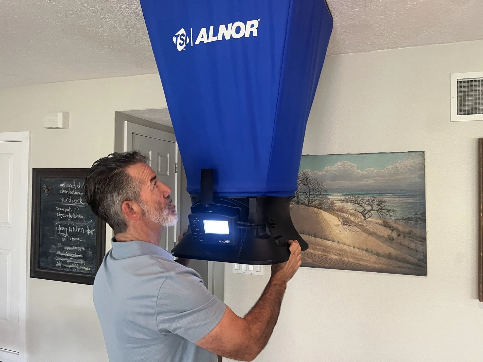 Rater measuring airflow with a flow hood