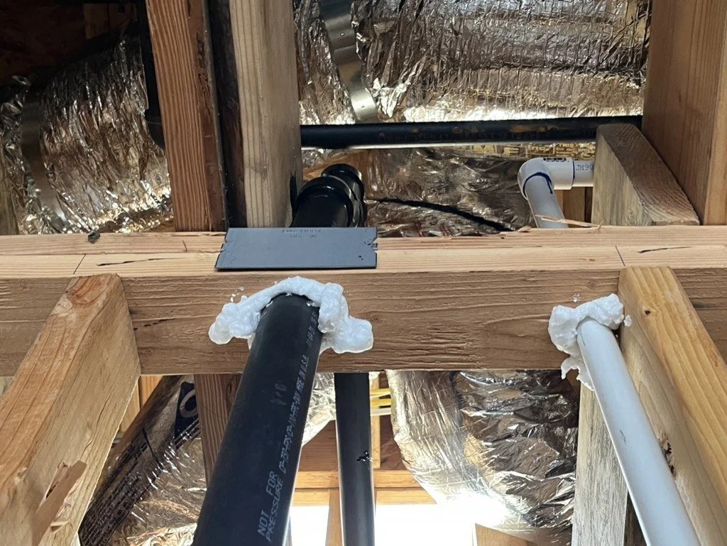 Plumbing pipes sealed with foam where they pass through the top plate