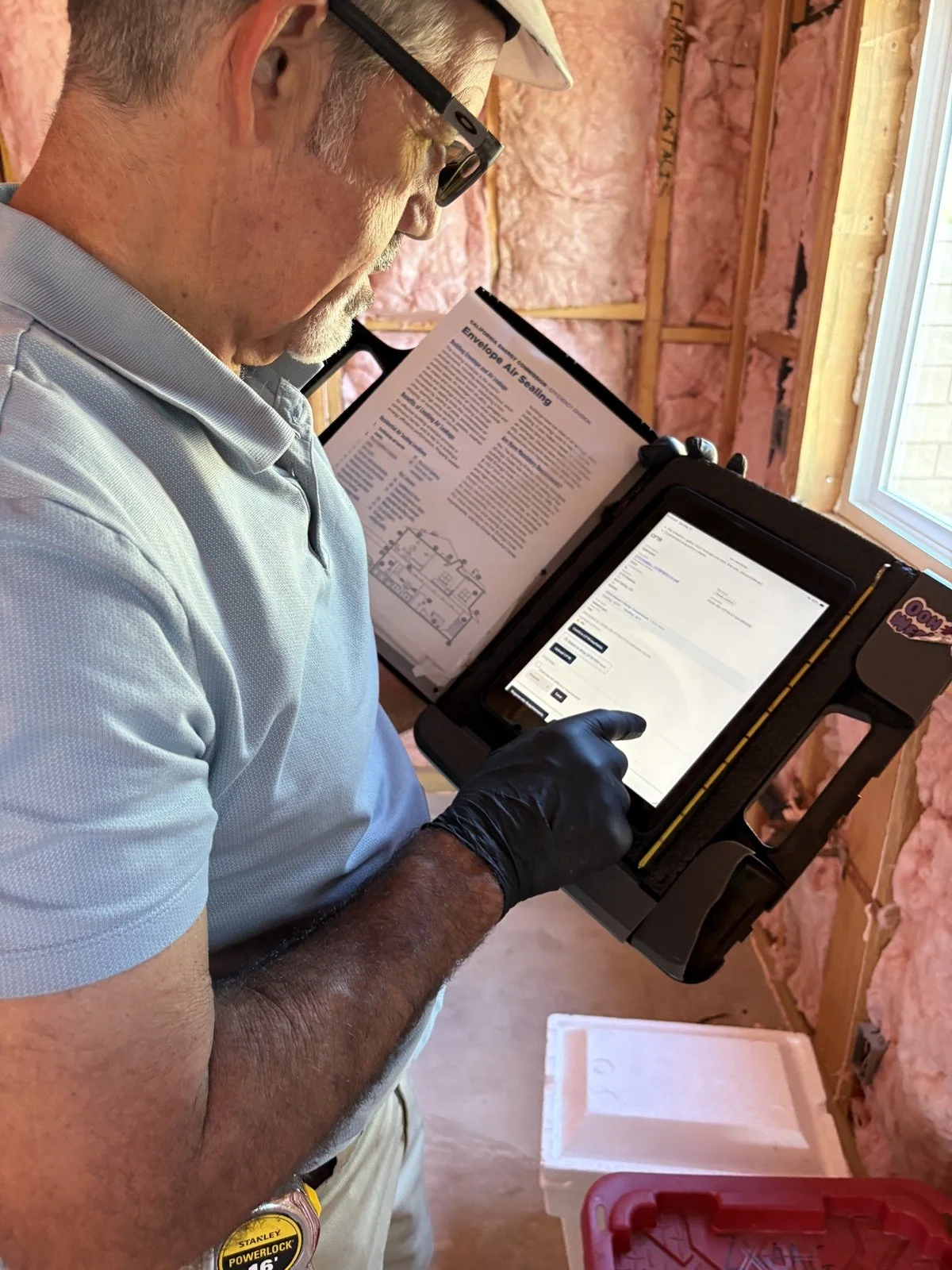 Rater using the field verification app on a custom clipboard rig during a QII inspection