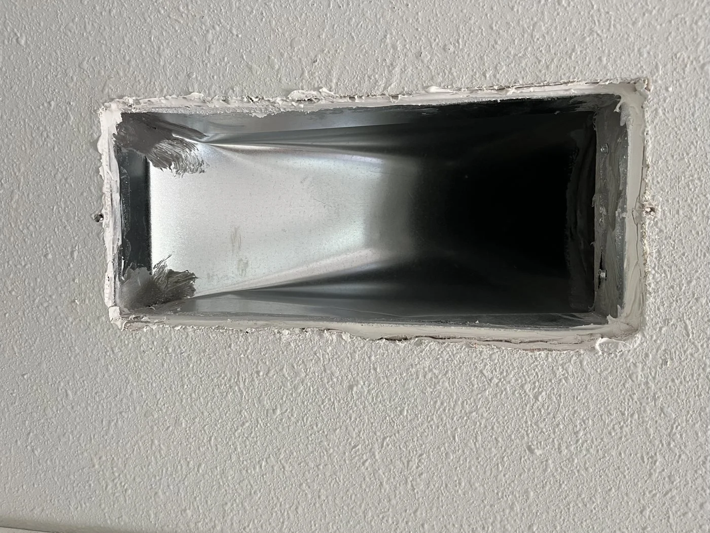 Register boot sealed to the drywall
