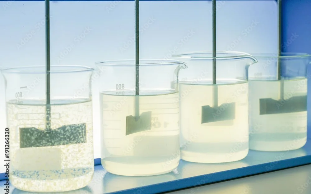 Jar test: four beakers of treated water on a paddle stirrer