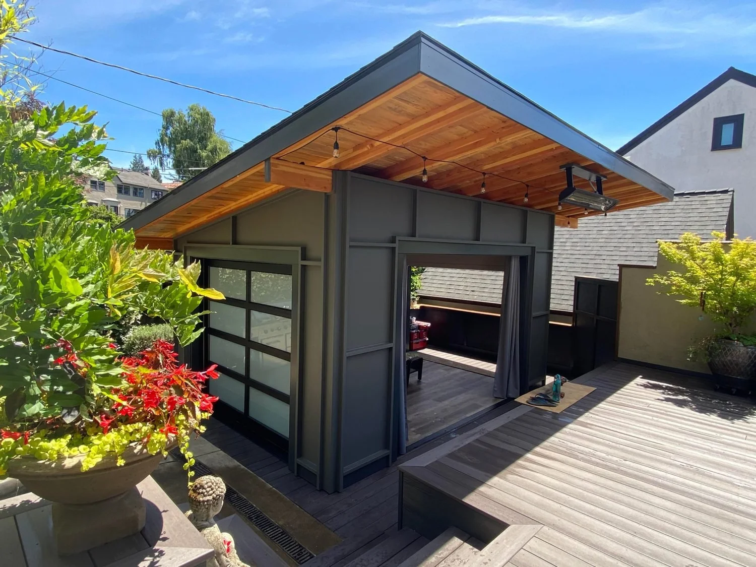 Backyard studio with cedar soffit, glass garage door and deck
