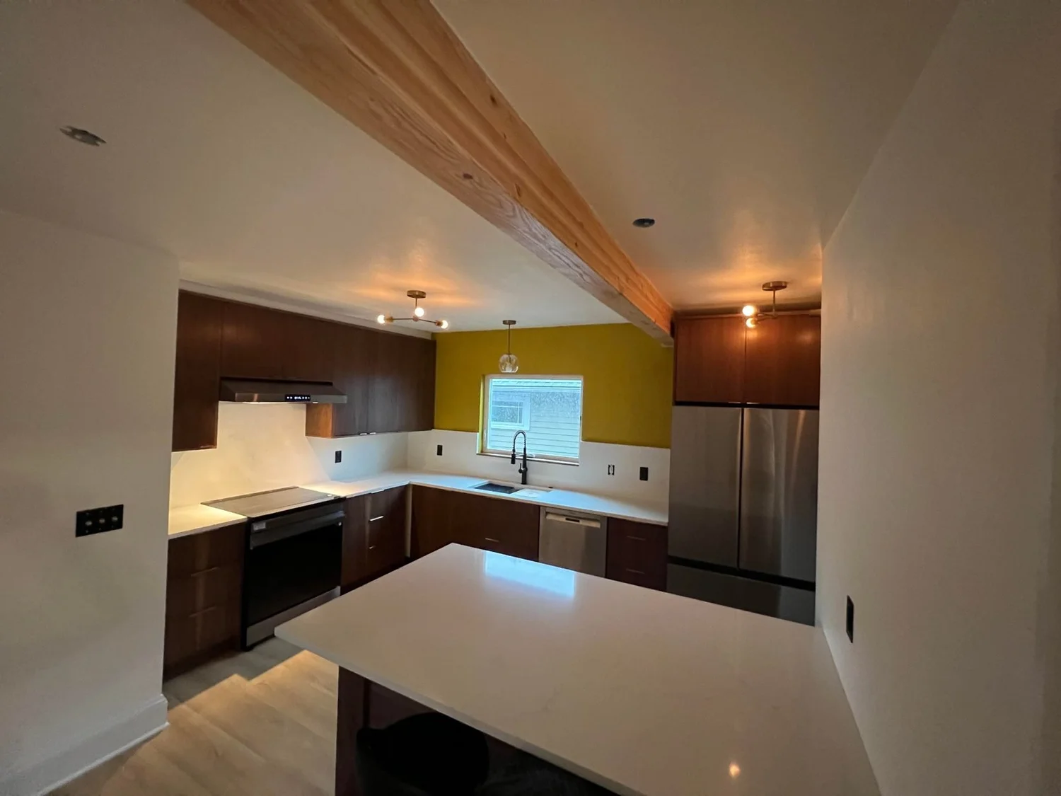 Lisle's kitchen with walnut cabinets, white quartz island and exposed wood beam