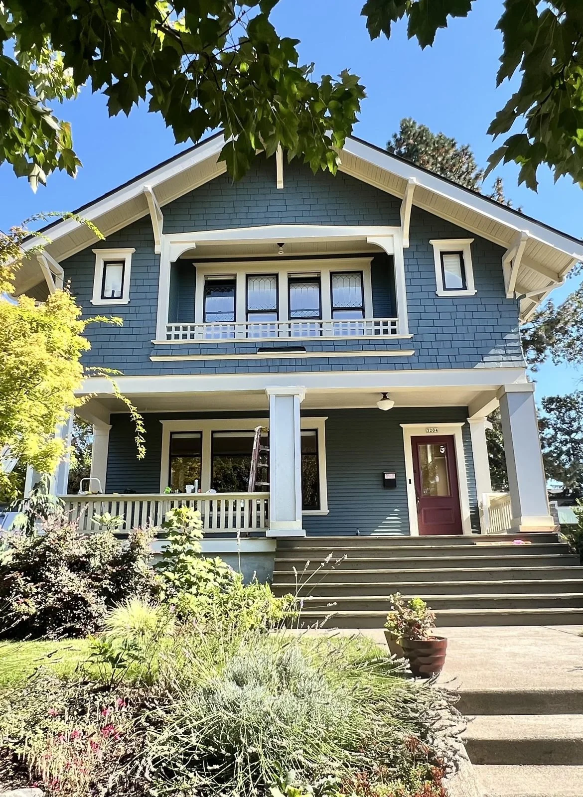 Restored blue Craftsman house with white trim and front porch