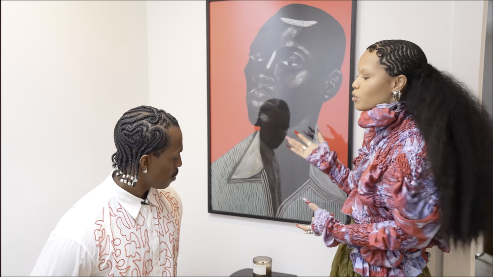 Skylar and Temi beside a framed portrait with a red ground
